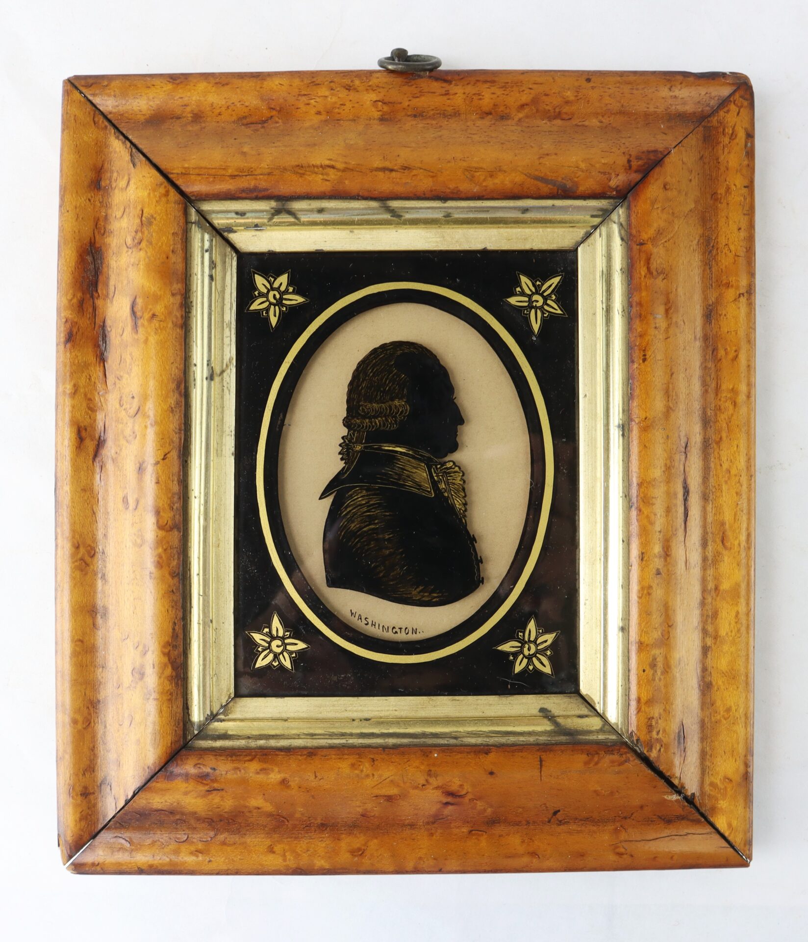 Framed silhouette portrait of a man in profile with the name "Washington" below, set in a wooden frame with decorative accents.
