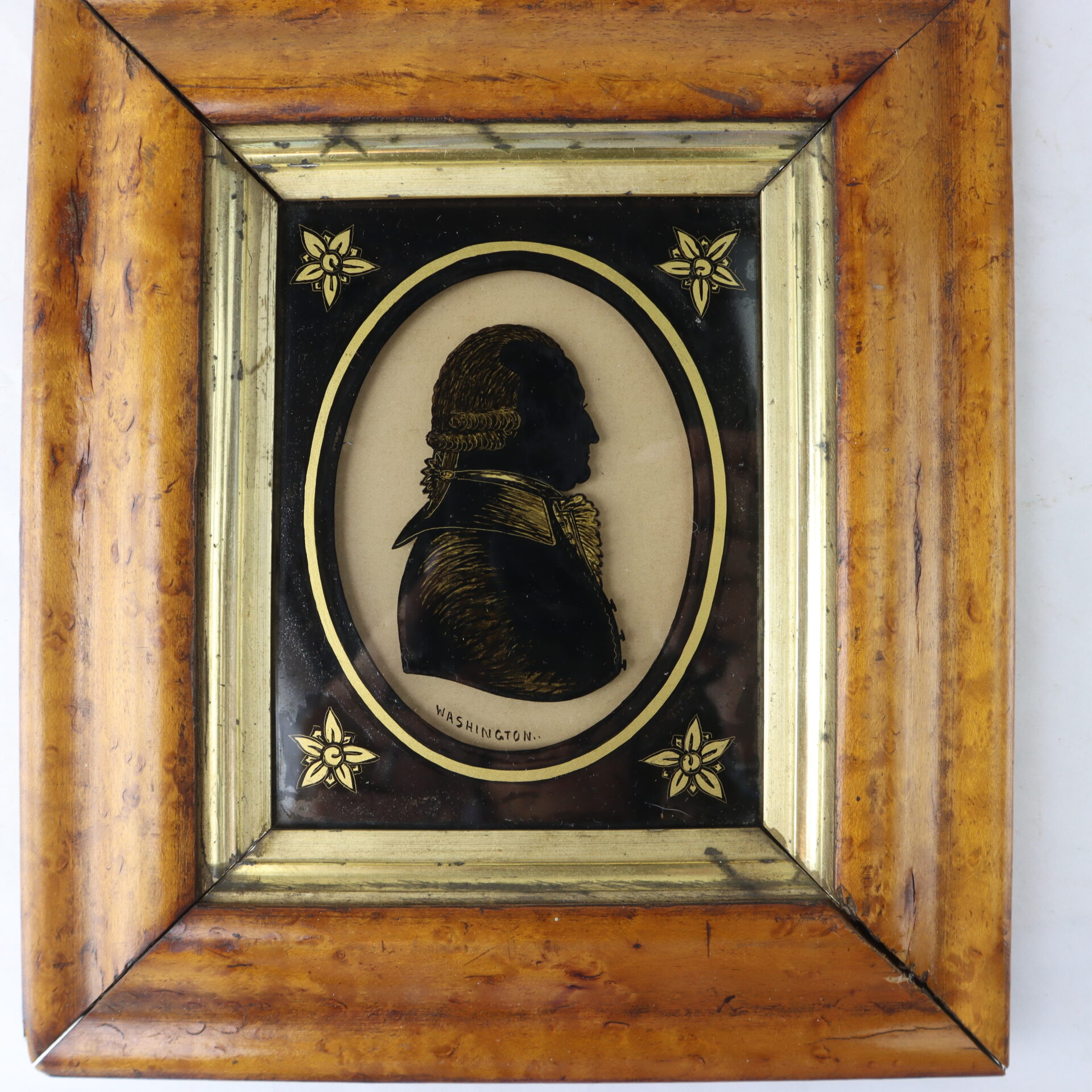 Framed silhouette portrait of a man in profile with "WASHINGTON" labeled below, featuring black and gold decorative border and wooden frame.
