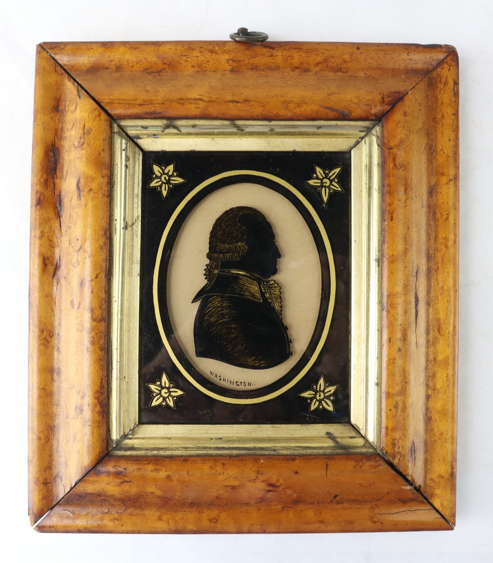 Framed silhouette portrait of a man in profile with the label "WASHINGTON" below, in a wooden frame with gold floral accents on each corner.