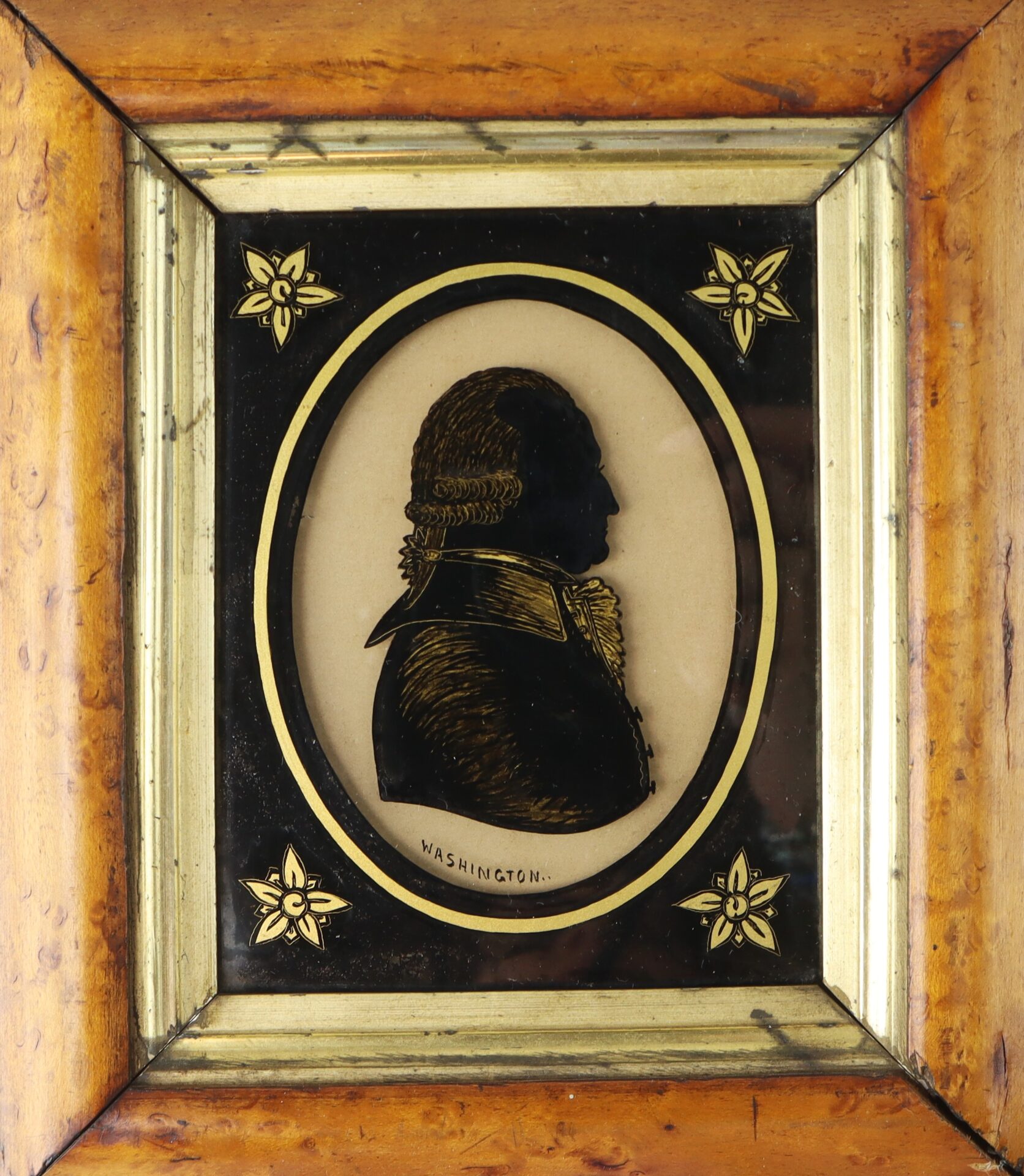 Framed silhouette portrait of a man in historical attire, labeled "Washington," with decorative gold accents on the corners.