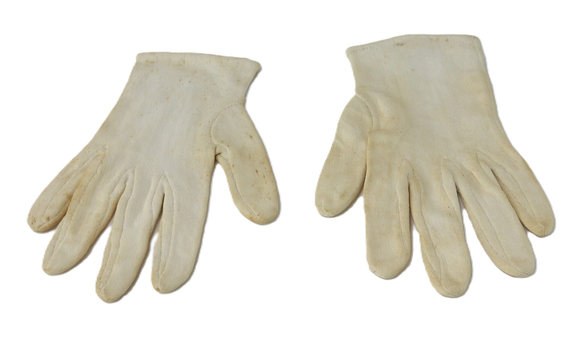 A pair of off-white gloves laid flat on a white background, with visible signs of wear and slight discoloration.