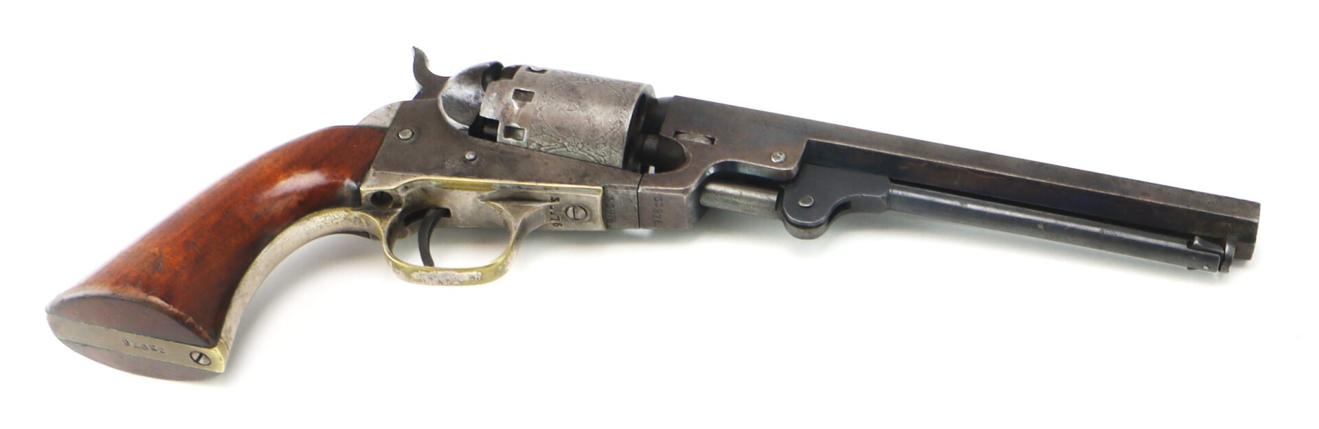 Antique revolver with a wooden handle, metal trigger guard, and long barrel, displayed against a white background.