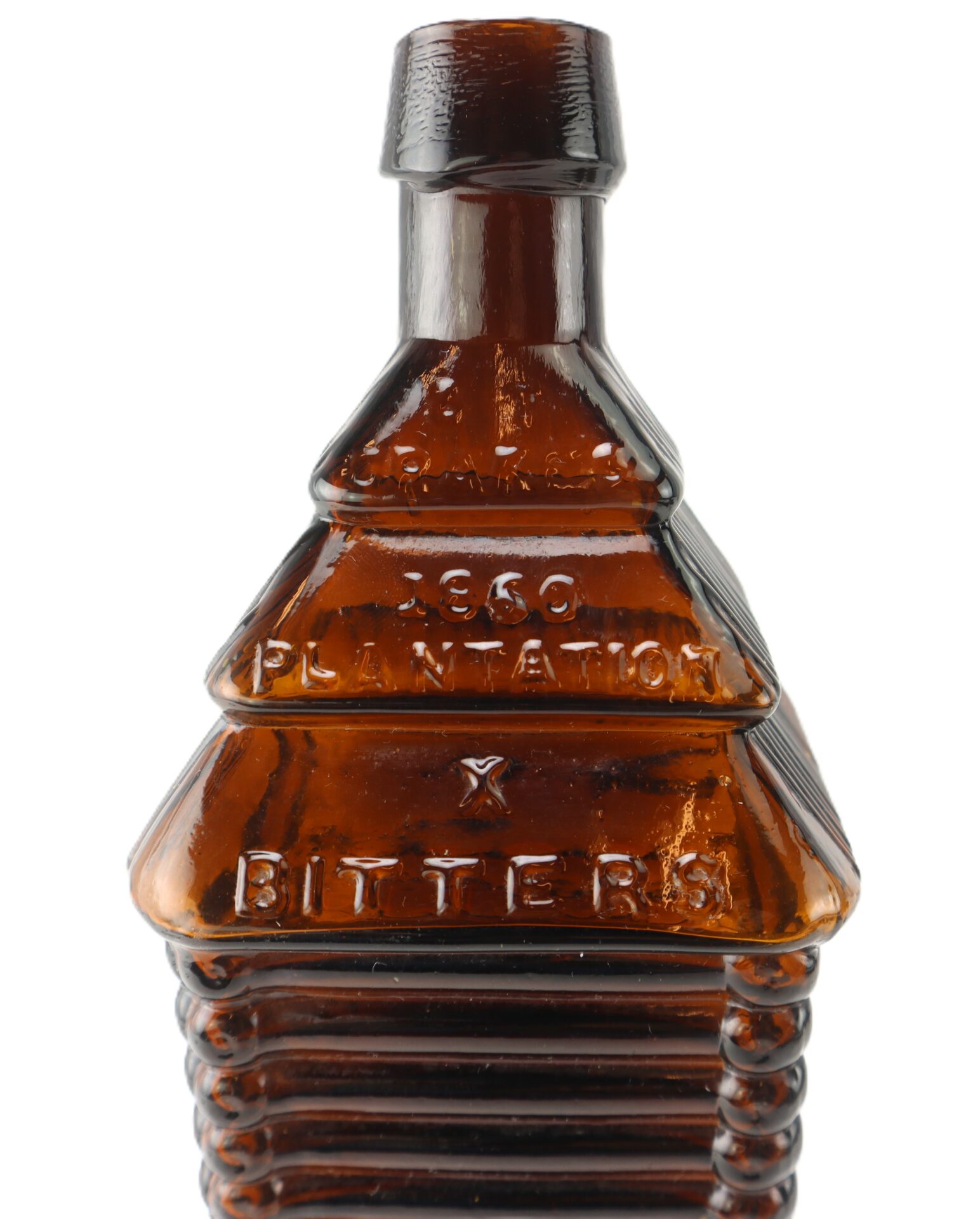 Amber glass bottle shaped like a log cabin, embossed with the words "350 PLANTATION BITTERS" on the front.