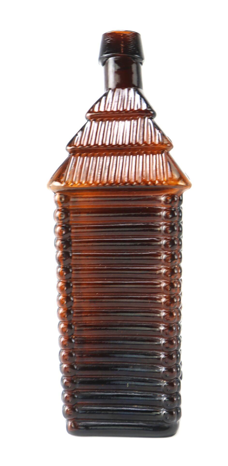 Brown glass bottle designed to resemble a log cabin, with a textured surface and a square base.