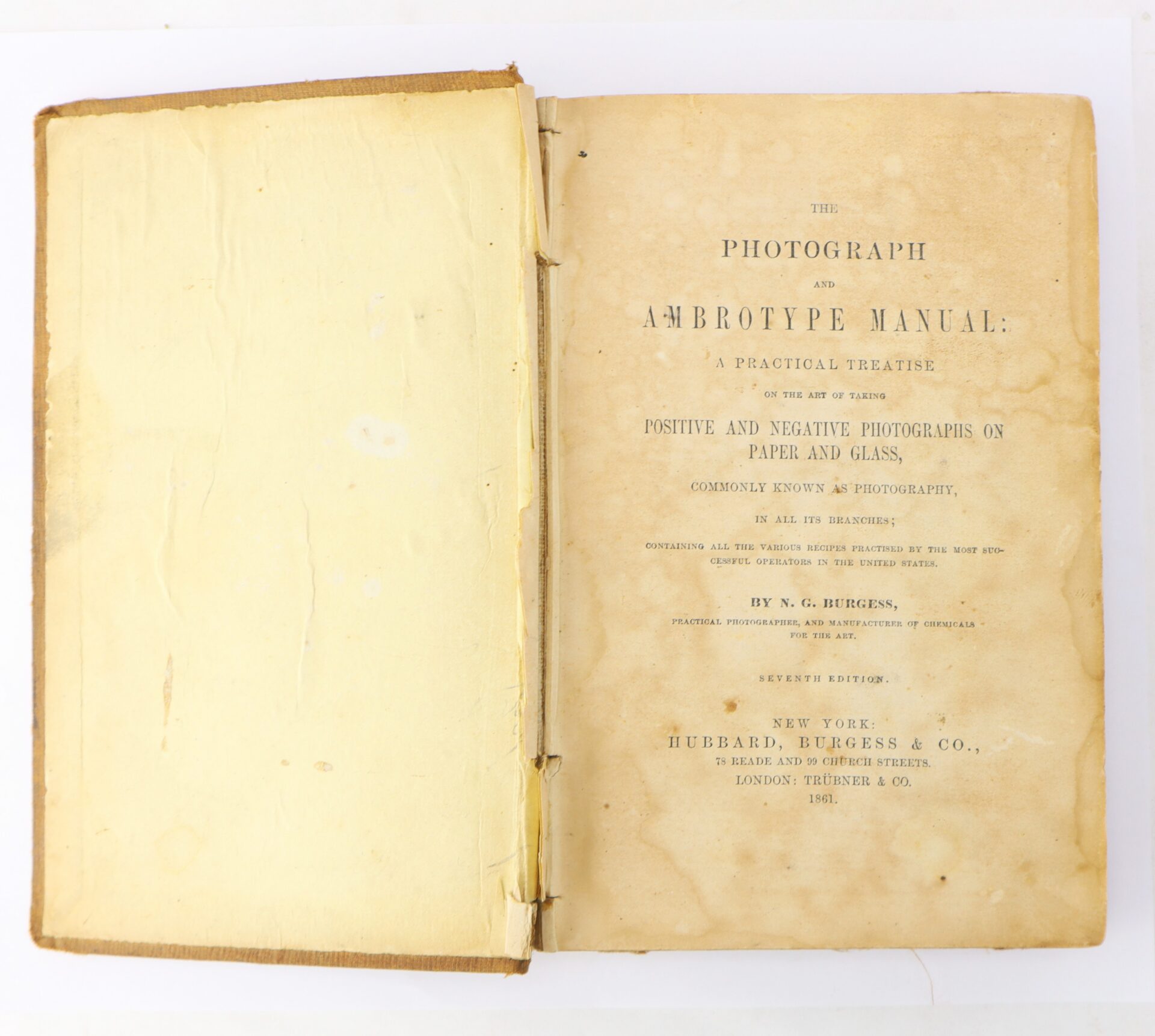 An open antique book titled "The Photograph and Ambrotype Manual" with yellowed pages and worn edges. The right page shows the book's title and publication details.