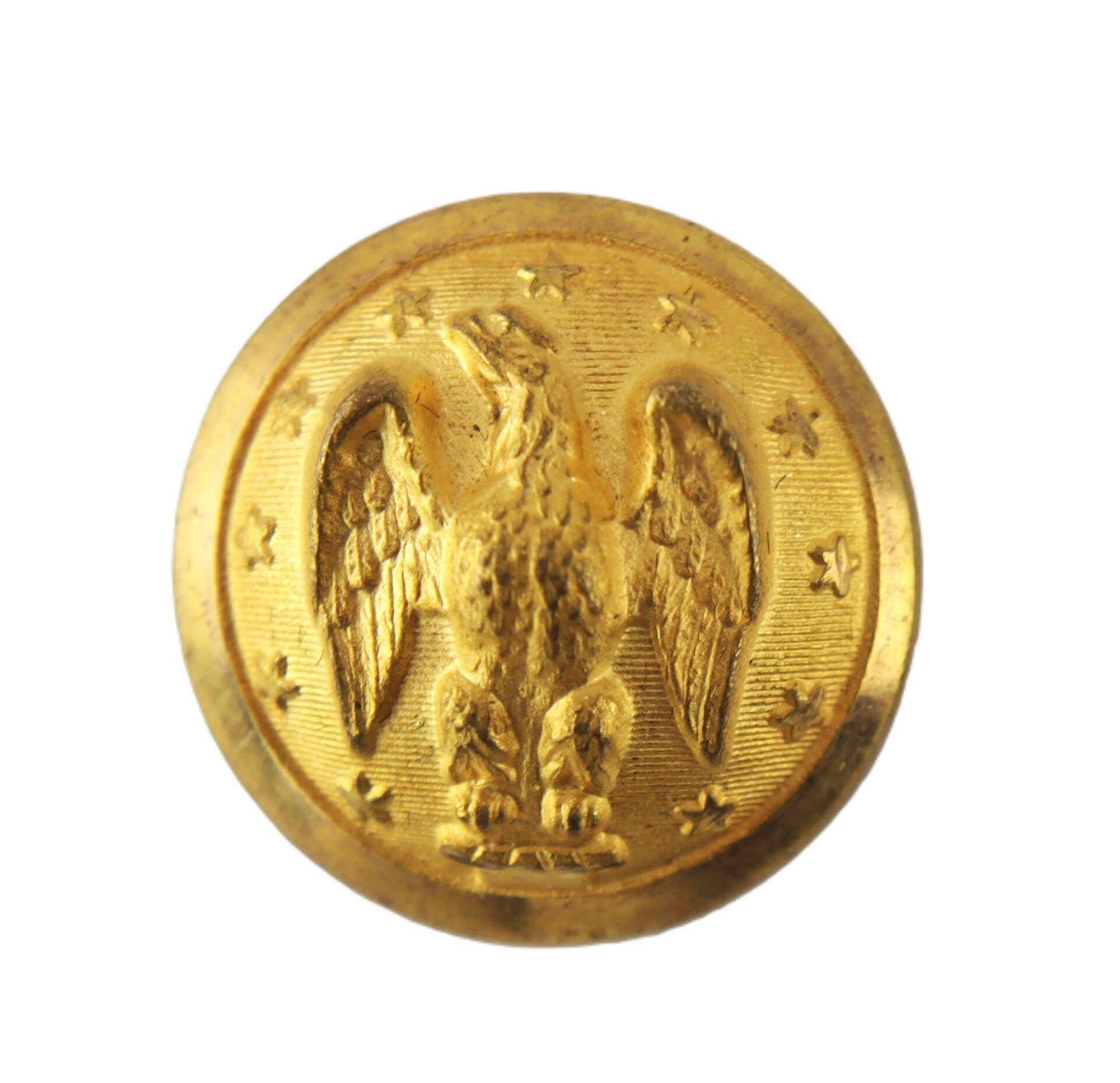 A round, gold button featuring an embossed eagle with outstretched wings and surrounded by small stars.