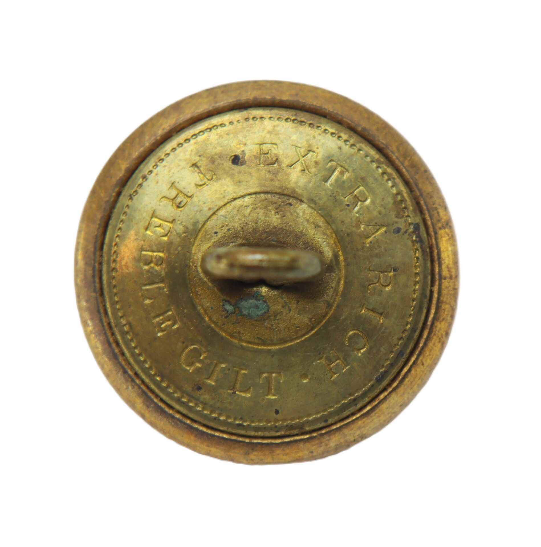 Round brass button with a loop shank, inscribed "EXTRA RICH TREBLE GILT" around the edge; surface shows signs of tarnish and wear.