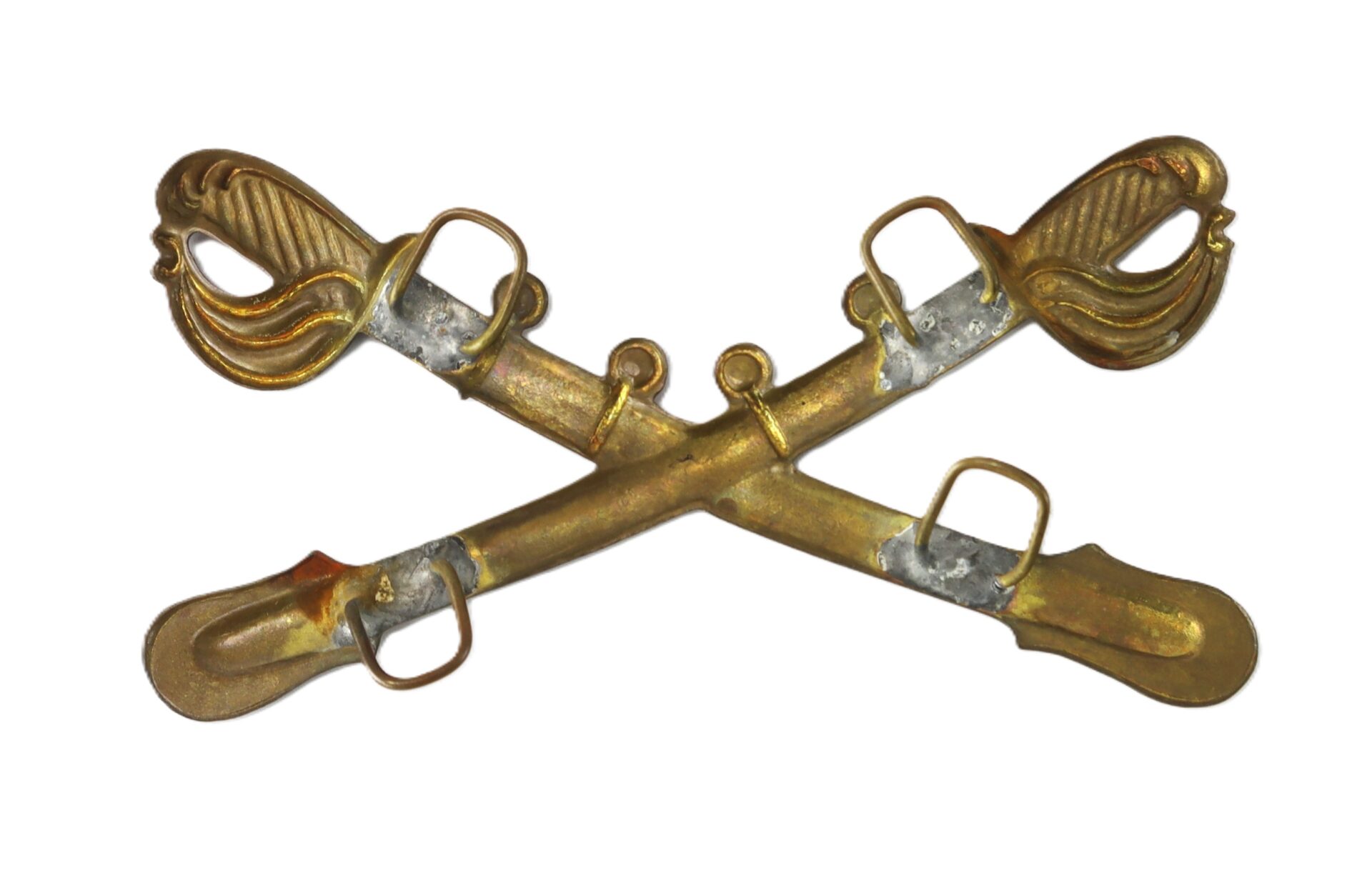 A brass crossed sabers insignia, typically used to represent the United States Army Cavalry branch.