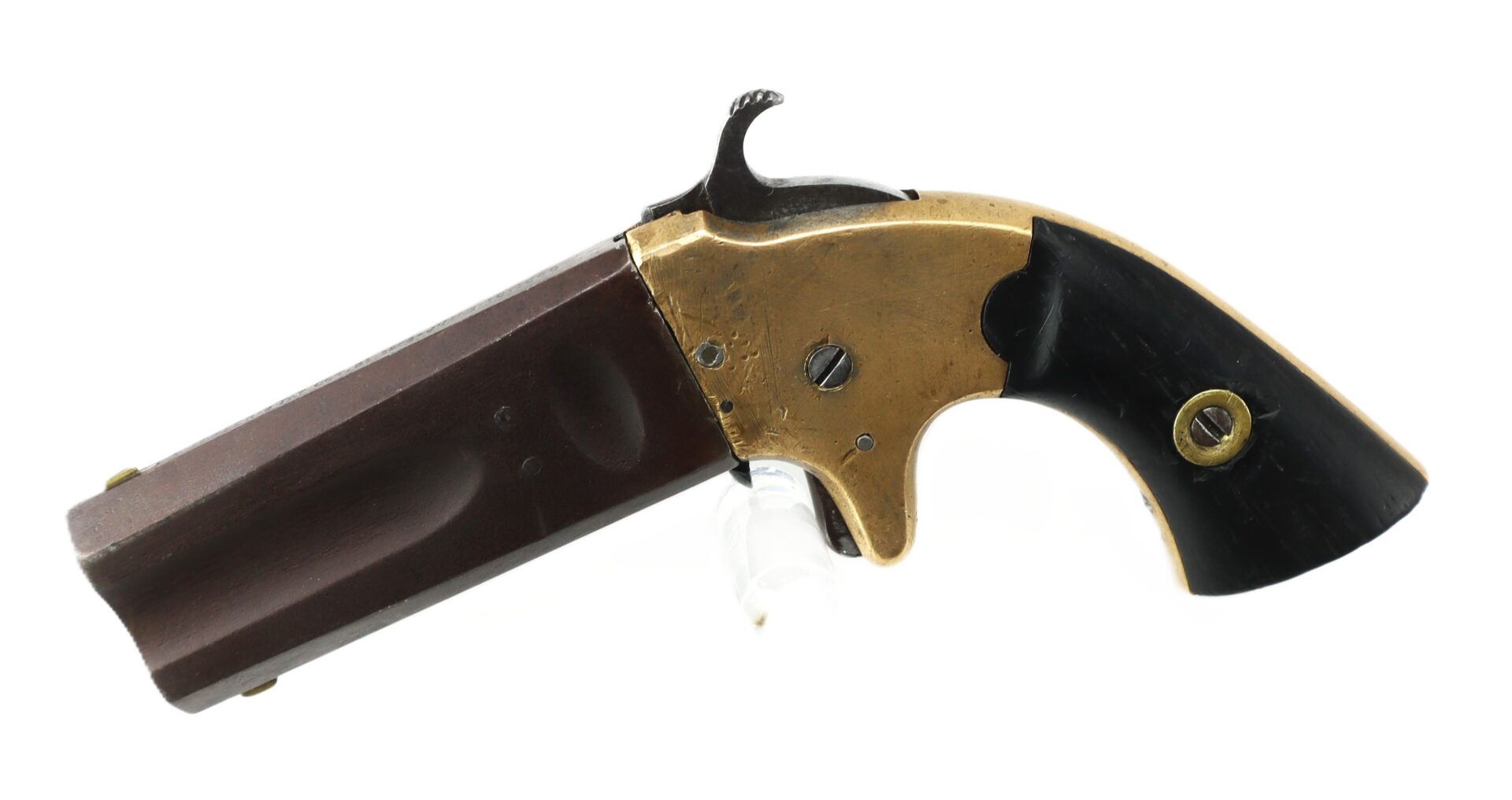 A small antique derringer-style pistol with a brass frame, dark barrel, and black grip is displayed on a white background.