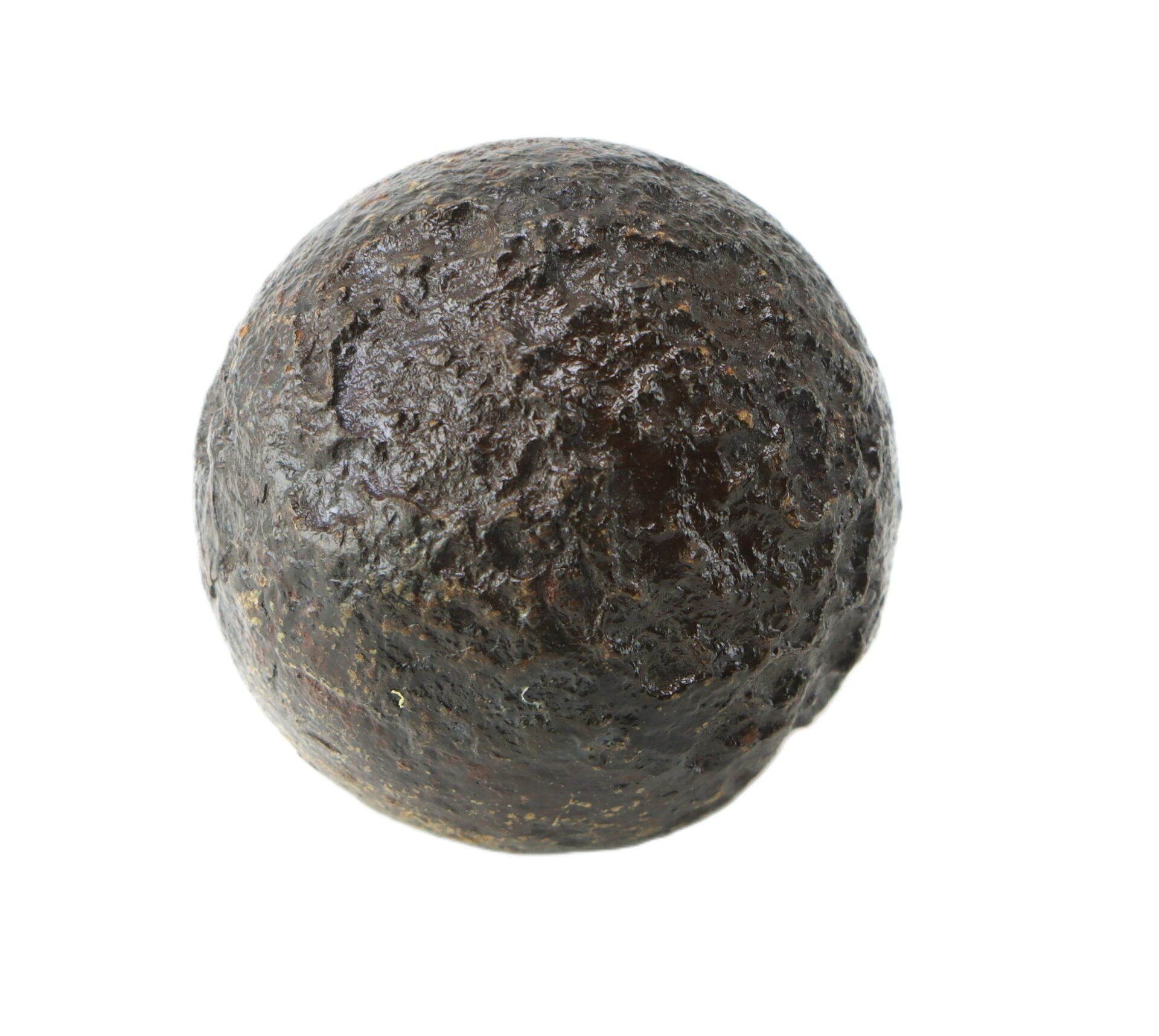 A dark, rough-textured, spherical metal object, resembling an old cannonball, set against a white background.