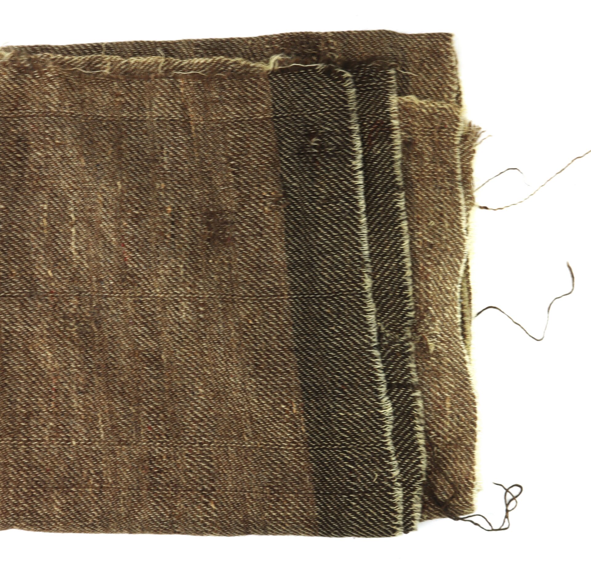 A close-up of folded, brown, textured fabric with frayed edges and a few loose threads on a white background.