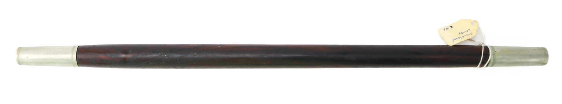 A dark wooden walking stick with metal caps on both ends and a tagged string tied near one end.