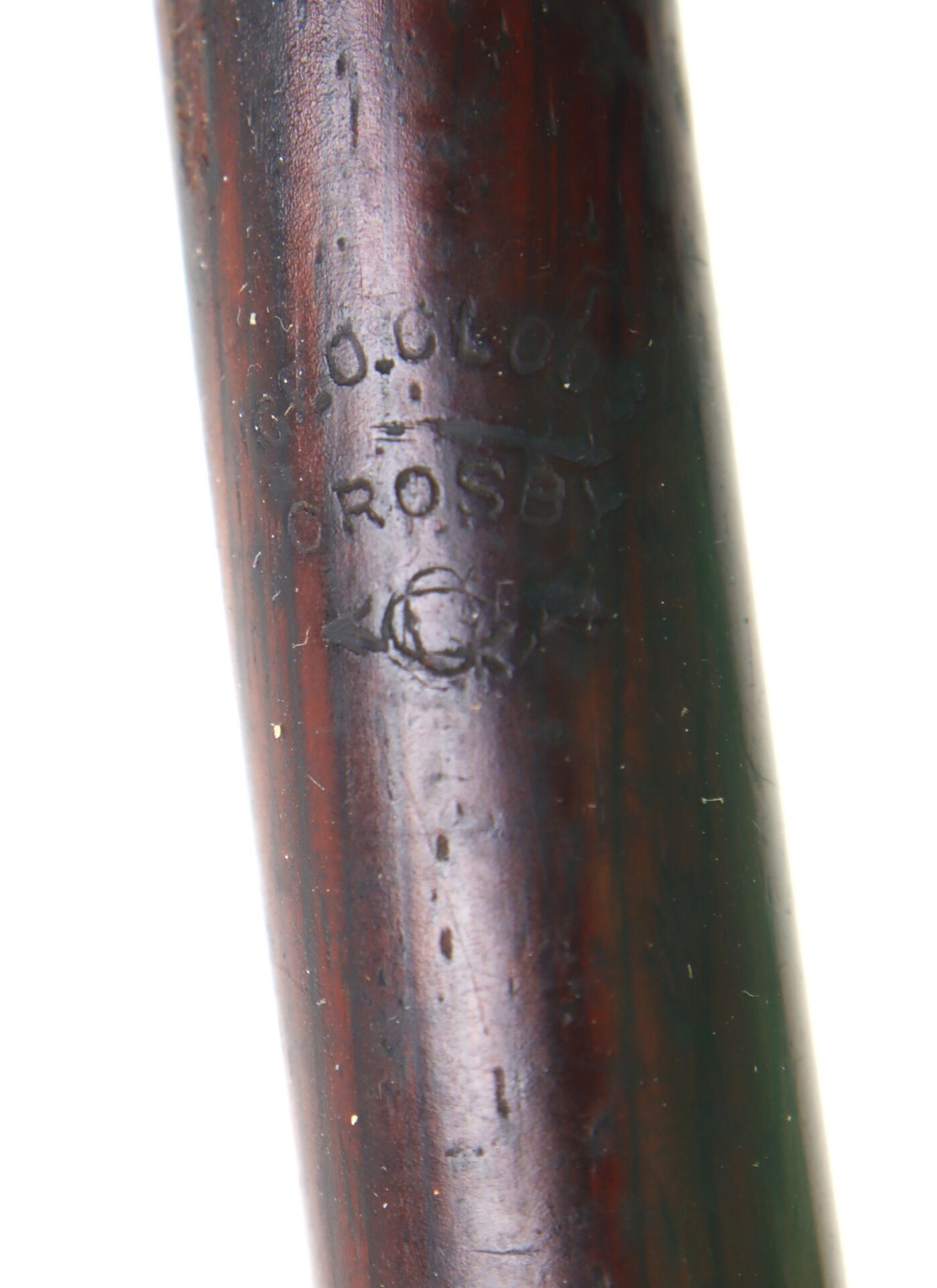 Close-up of a wooden object with stamped text that reads “G. G. CLODE CROSBY” and a circular mark below the text.