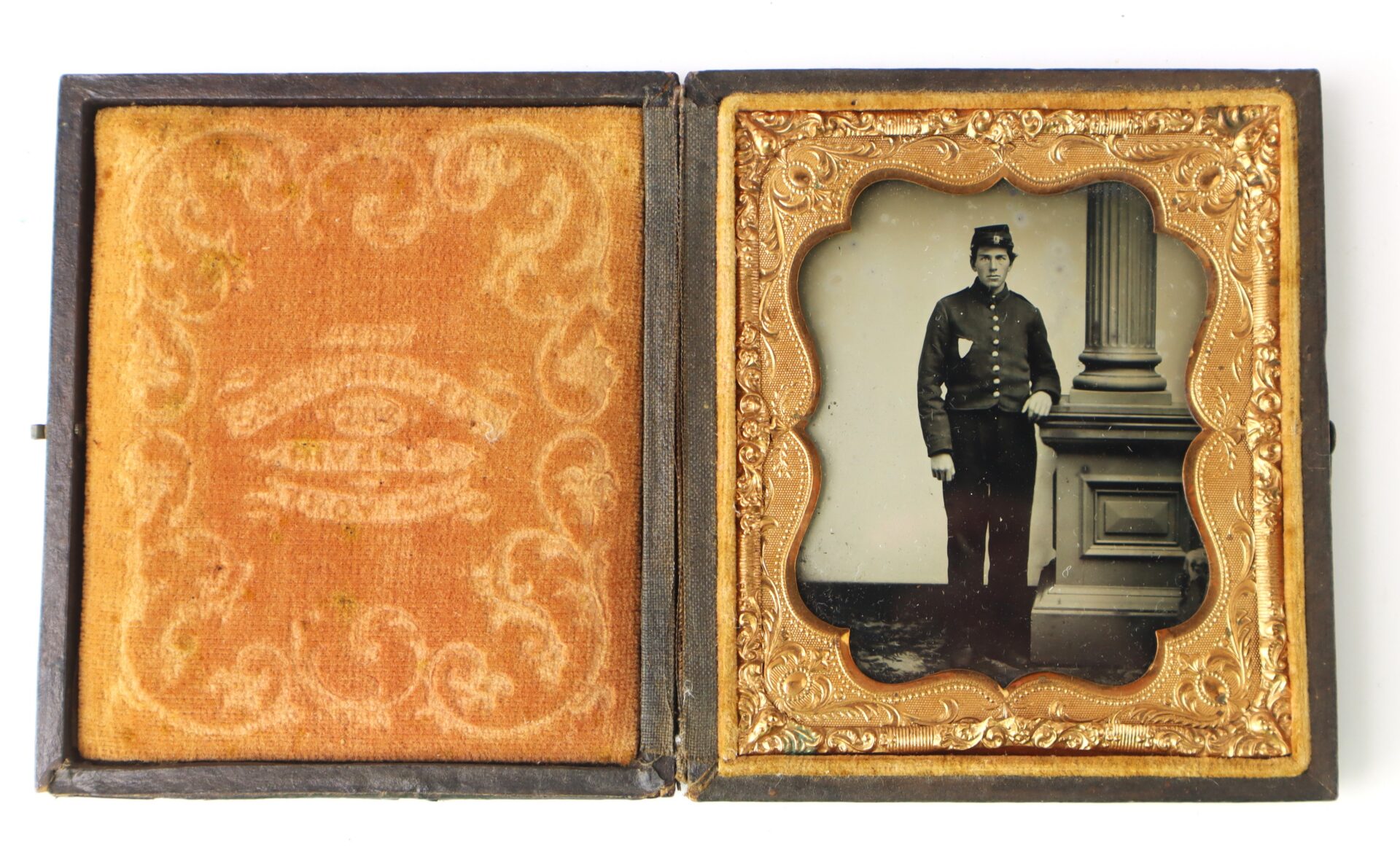 An old photograph in a decorative case shows a man in a military uniform standing beside a large pillar.