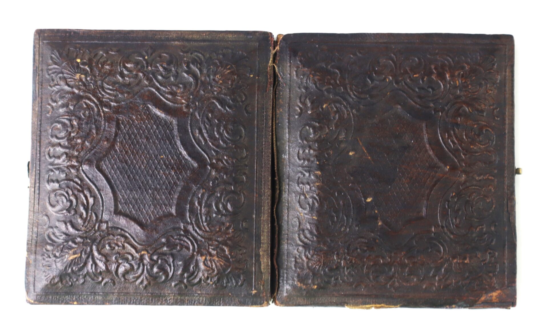 Closed, ornately embossed dark brown leather case with symmetrical decorative patterns, displayed on a white background.