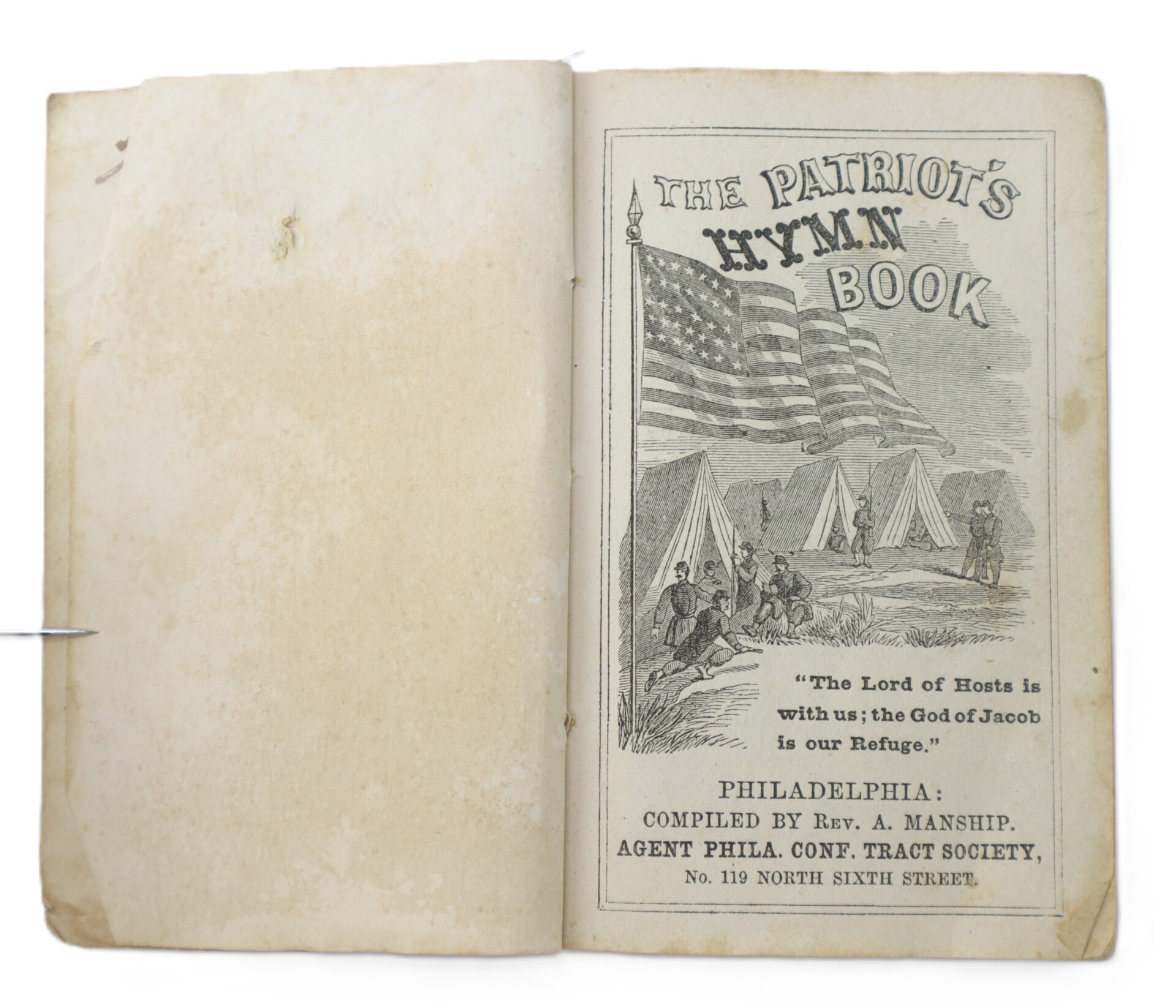 Open book showing the title page of "The Patriot's Hymn Book" featuring a drawing of tents, soldiers, and American flags, with a Bible verse and publication details below.