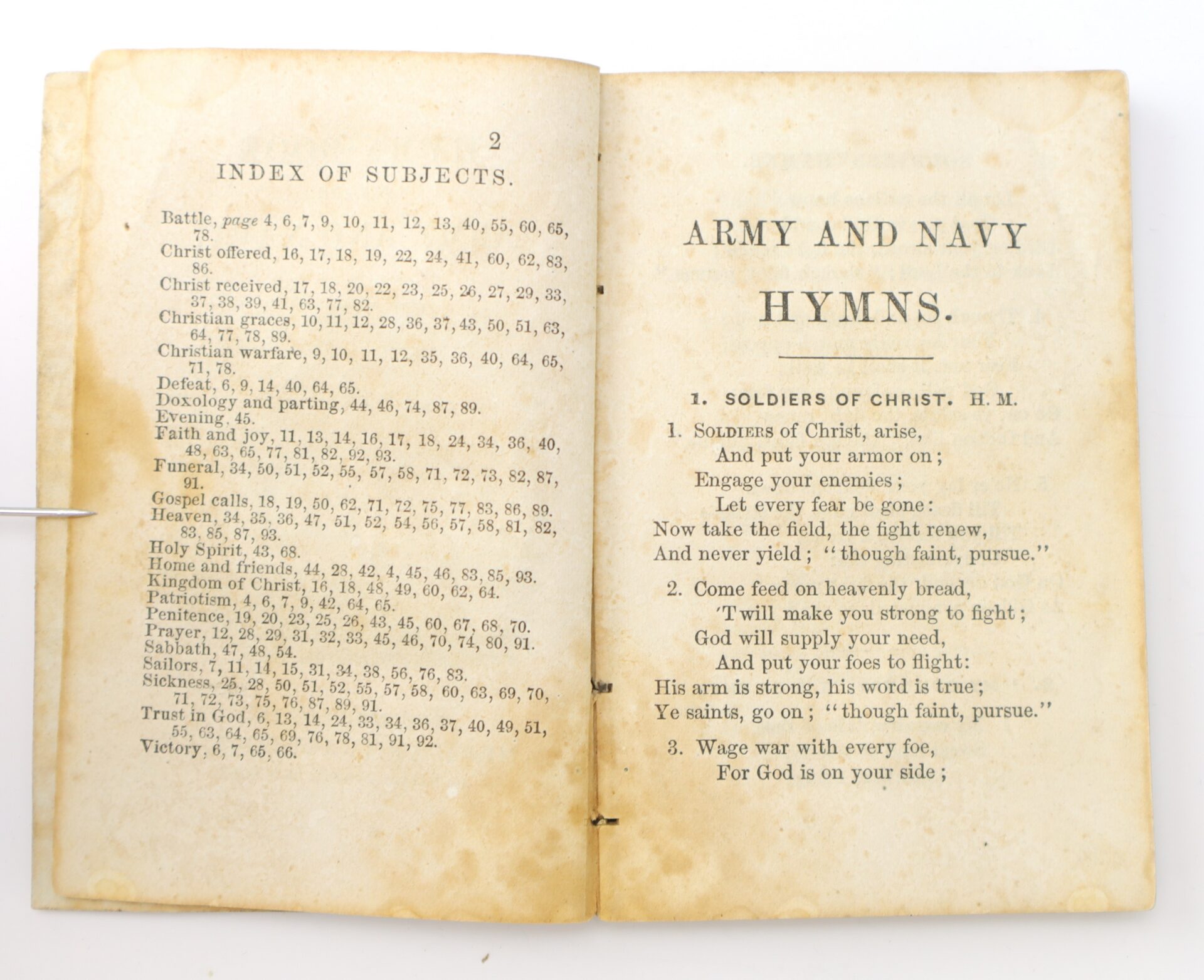 An open, aged book showing an index of subjects on the left page and the title "Army and Navy Hymns" with hymn lyrics on the right page.