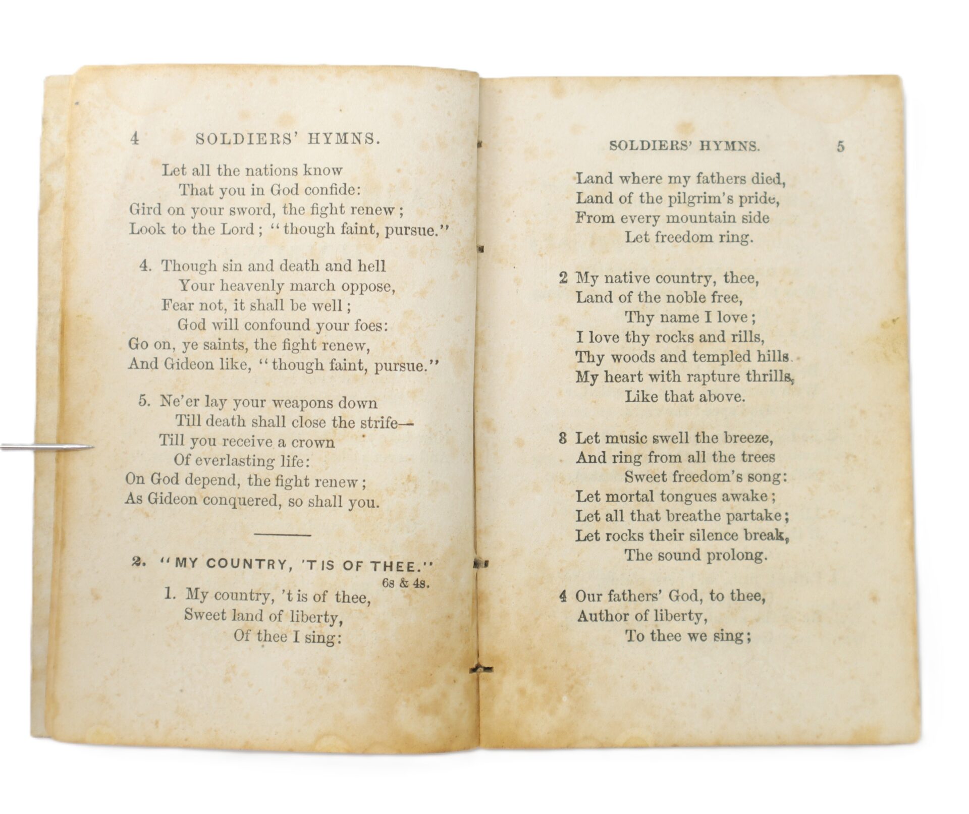 An open, aged book showing pages 4 and 5 with hymns titled "Soldiers' Hymns" and "'My Country, 'Tis of Thee,'" featuring yellowed pages and visible spots.