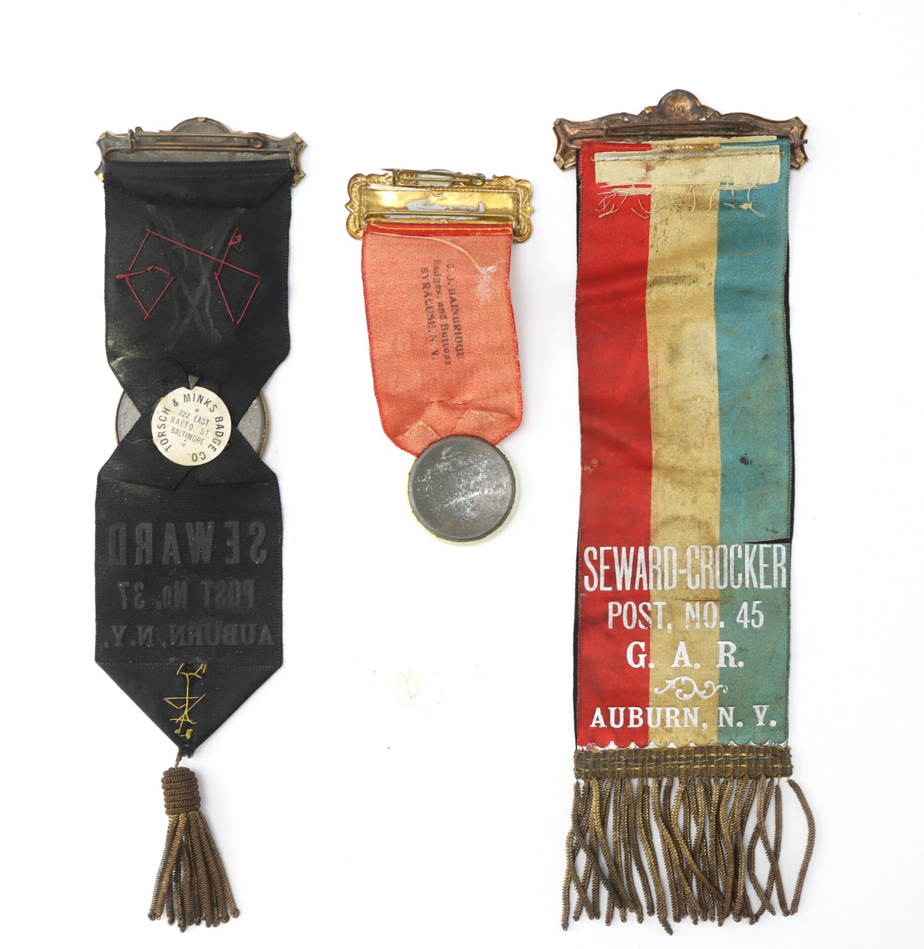 Three vintage ribbons with medals, including two from Seward-Crocker Post No. 45, G.A.R., Auburn, N.Y., and one faded red ribbon with a round silver medallion.