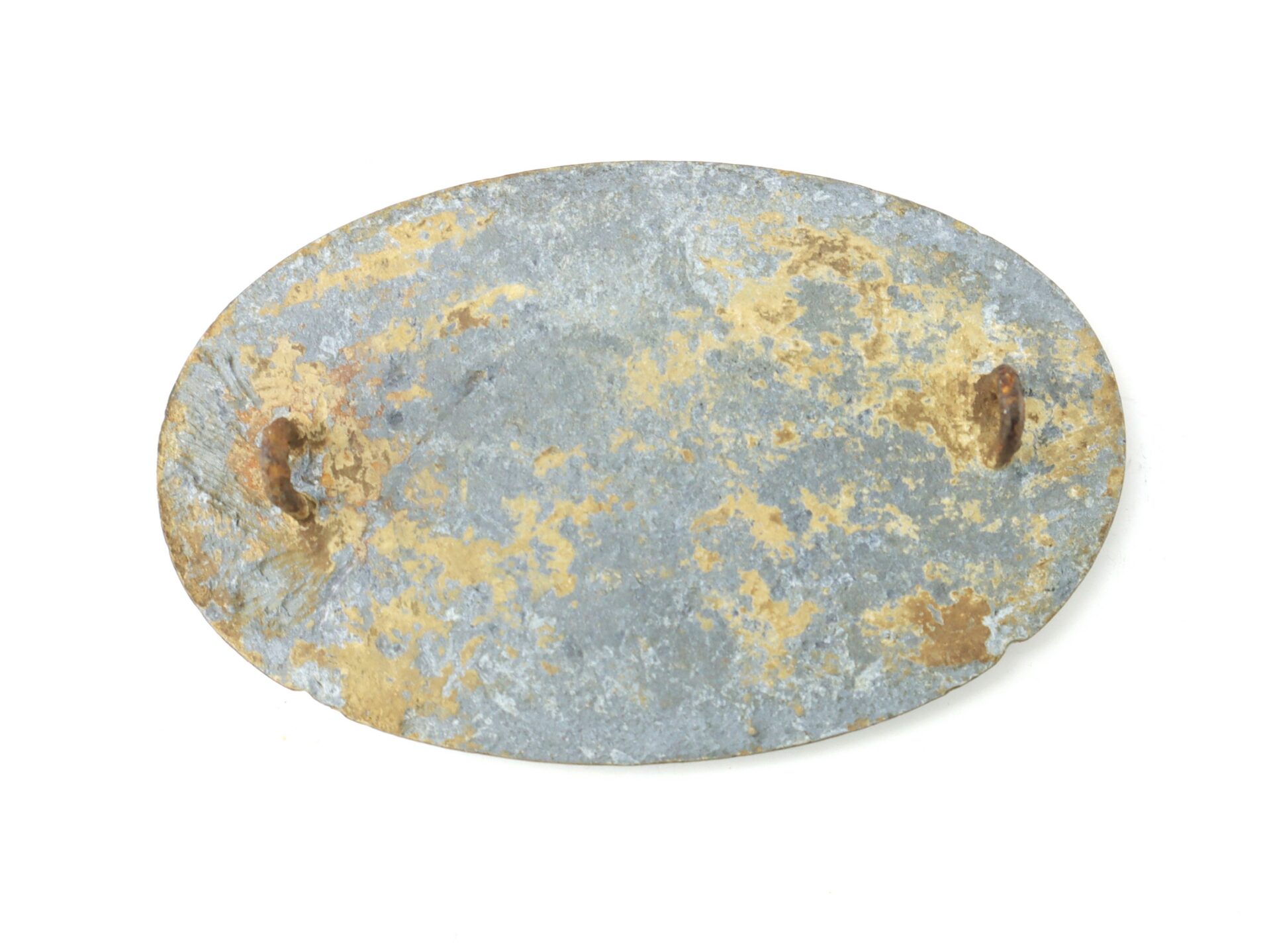 Oval-shaped, rusted metal plate with two small, corroded metal studs on either side, against a white background.