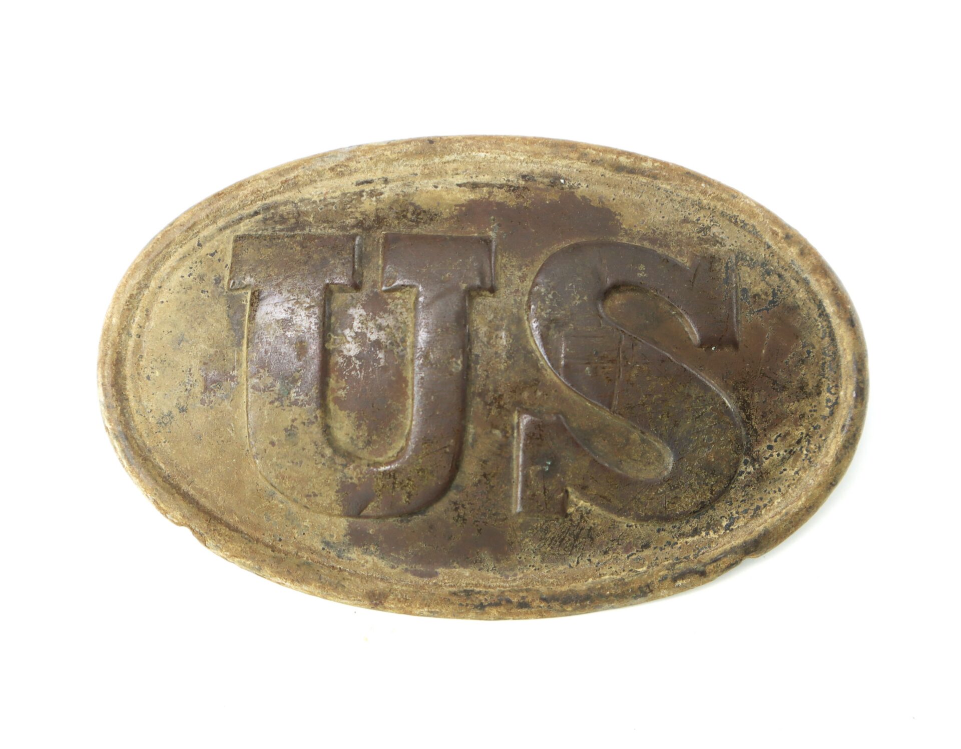 Oval-shaped, weathered brass plate with large raised letters "US," appearing to be an antique military belt buckle.