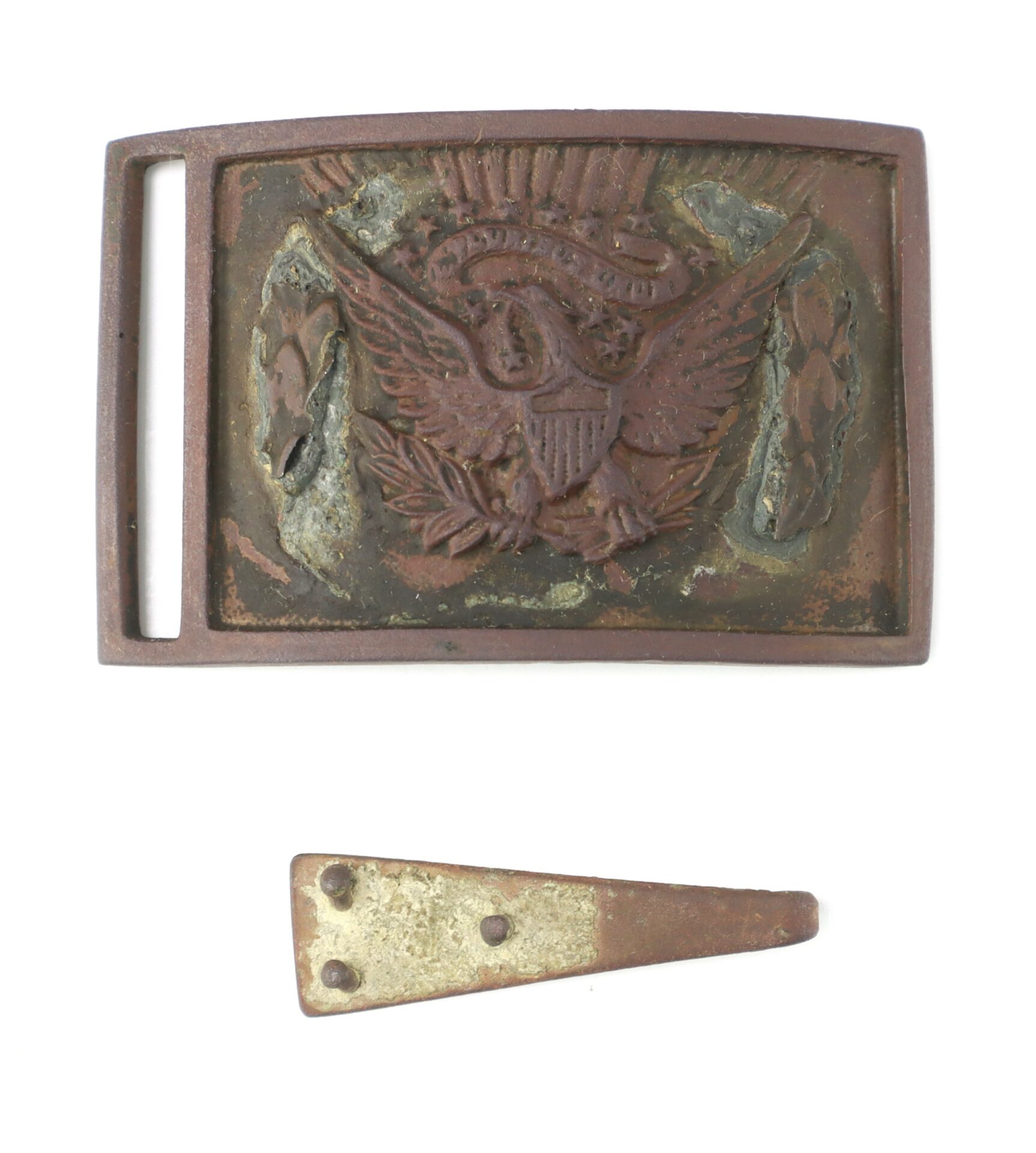 A worn, rectangular metal belt buckle with an embossed eagle emblem and a separate, small, triangular metal piece below it.