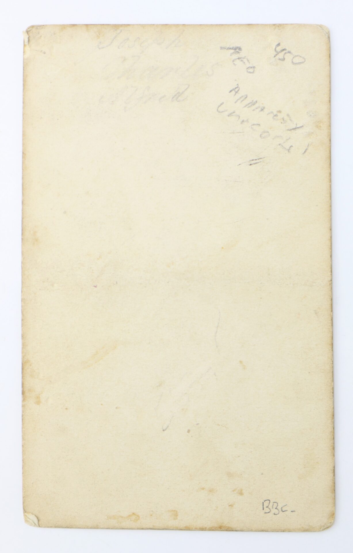 Aged, blank postcard back with faint, illegible handwritten notes and visible wear along the edges.