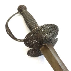 Antique sword with an ornate, perforated metal guard and a ribbed hilt, photographed on a white background.
