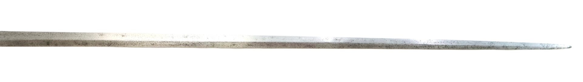 A close-up view of the pointed tip of a metal sword blade with a slightly worn and tarnished surface.