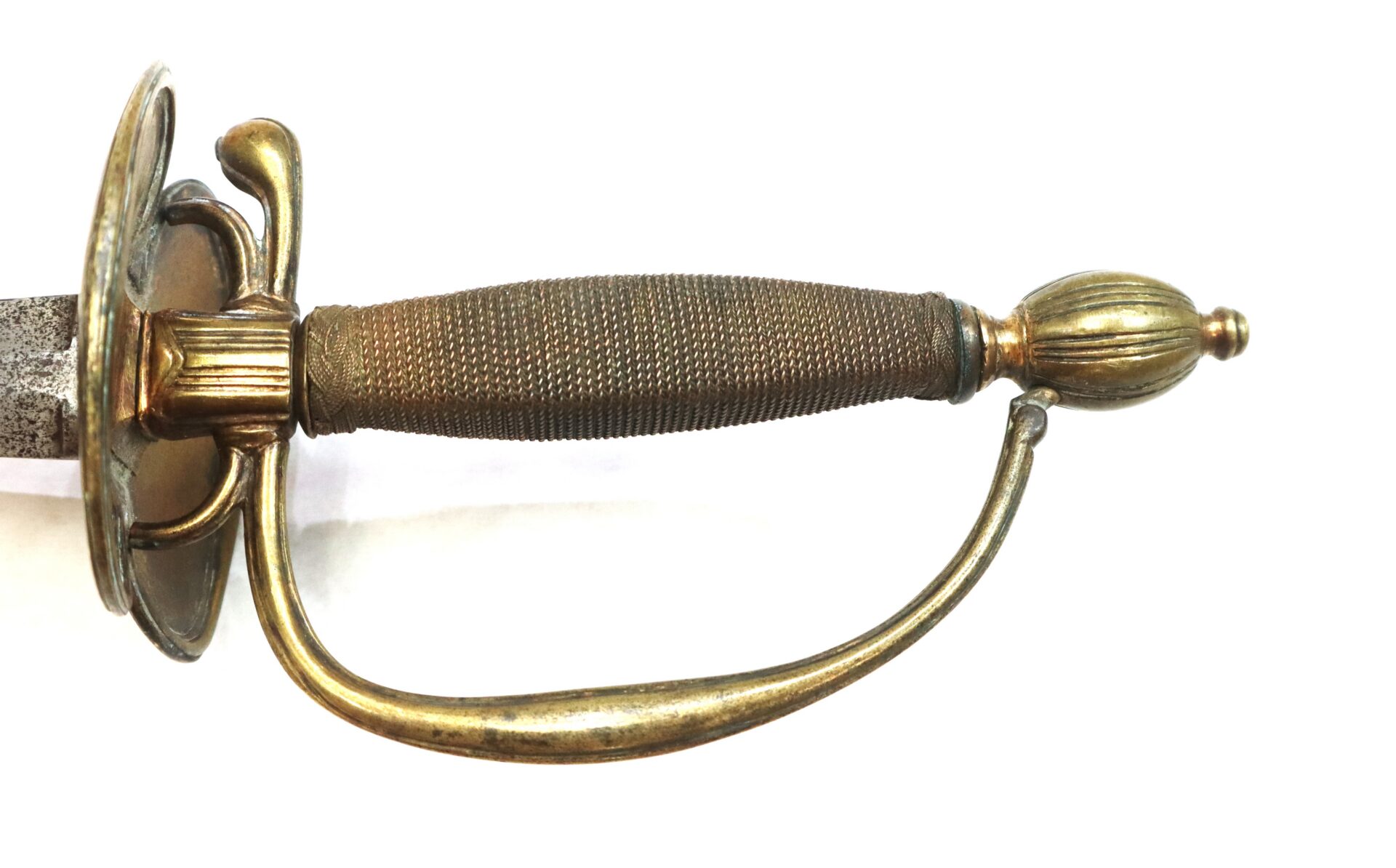 Close-up of a brass hilt smallsword with a detailed grip, knuckle guard, and shell guard, photographed on a white background.