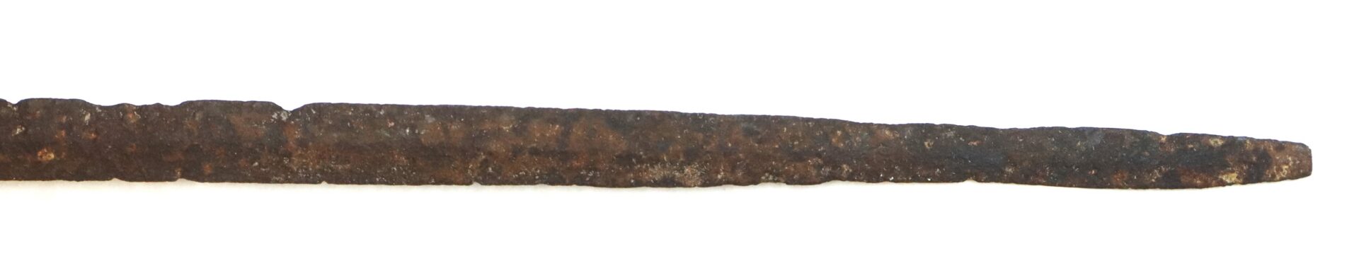 A long, narrow, rusted metal rod with a pointed tip, photographed on a white background.