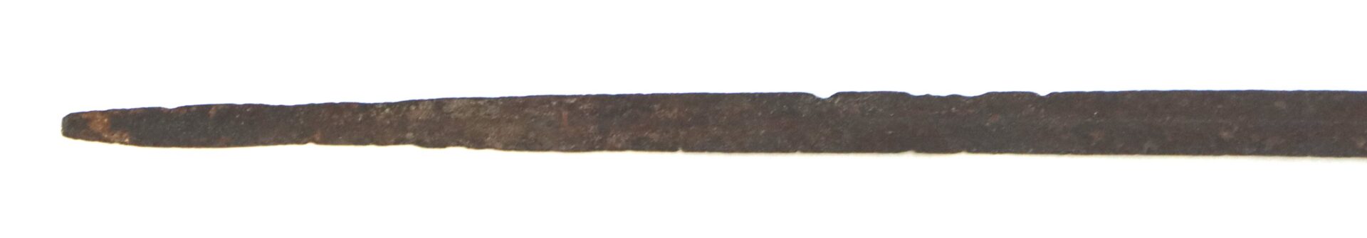 A close-up view of a rusty, pointed metal object, possibly an old nail or spike, isolated on a white background.
