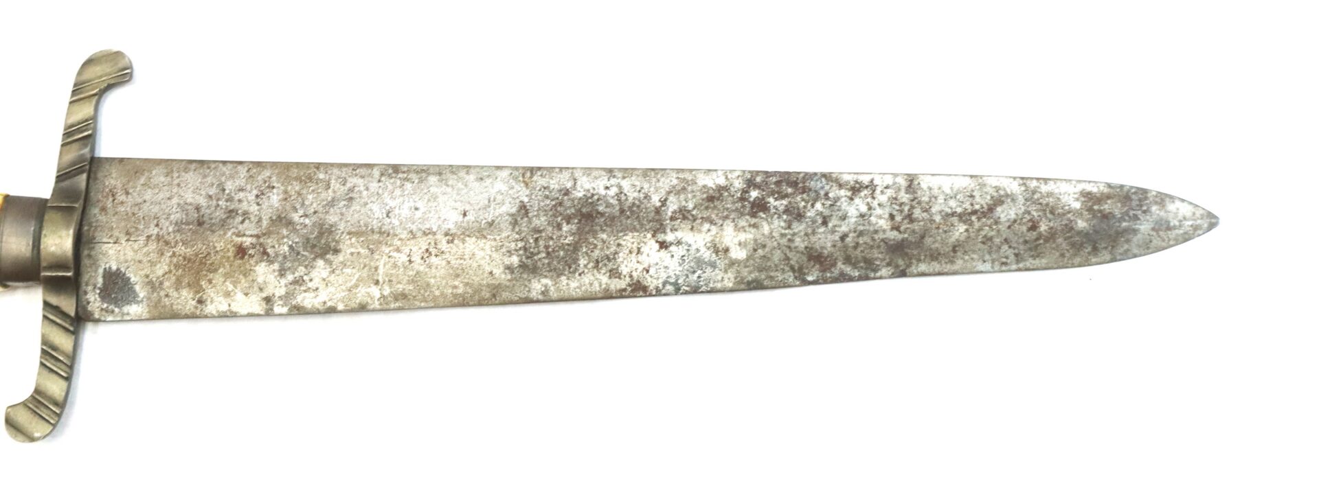 A close-up view of an old, weathered dagger blade with a straight edge and a simple crossguard, photographed against a white background.