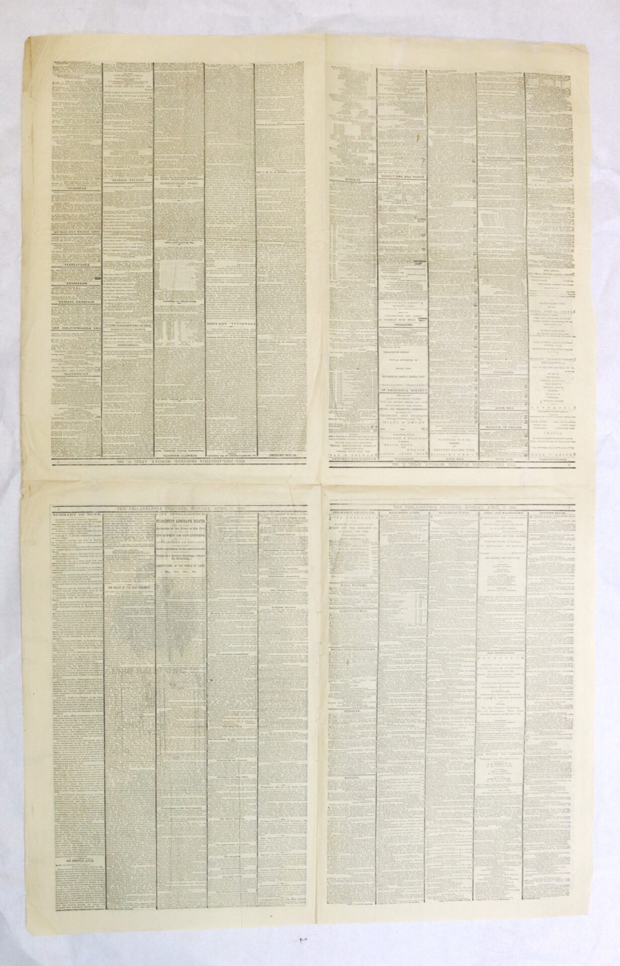 An old document with dense, small text printed in four vertical columns on each half of a large, yellowed sheet of paper, laid flat on a white background.