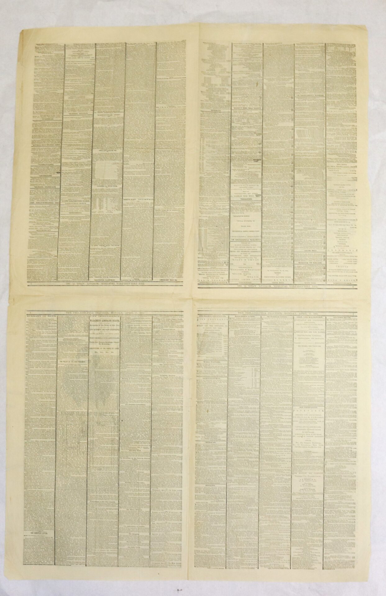 A large sheet of old paper divided into four sections, each filled with densely printed columns of small text in black ink.