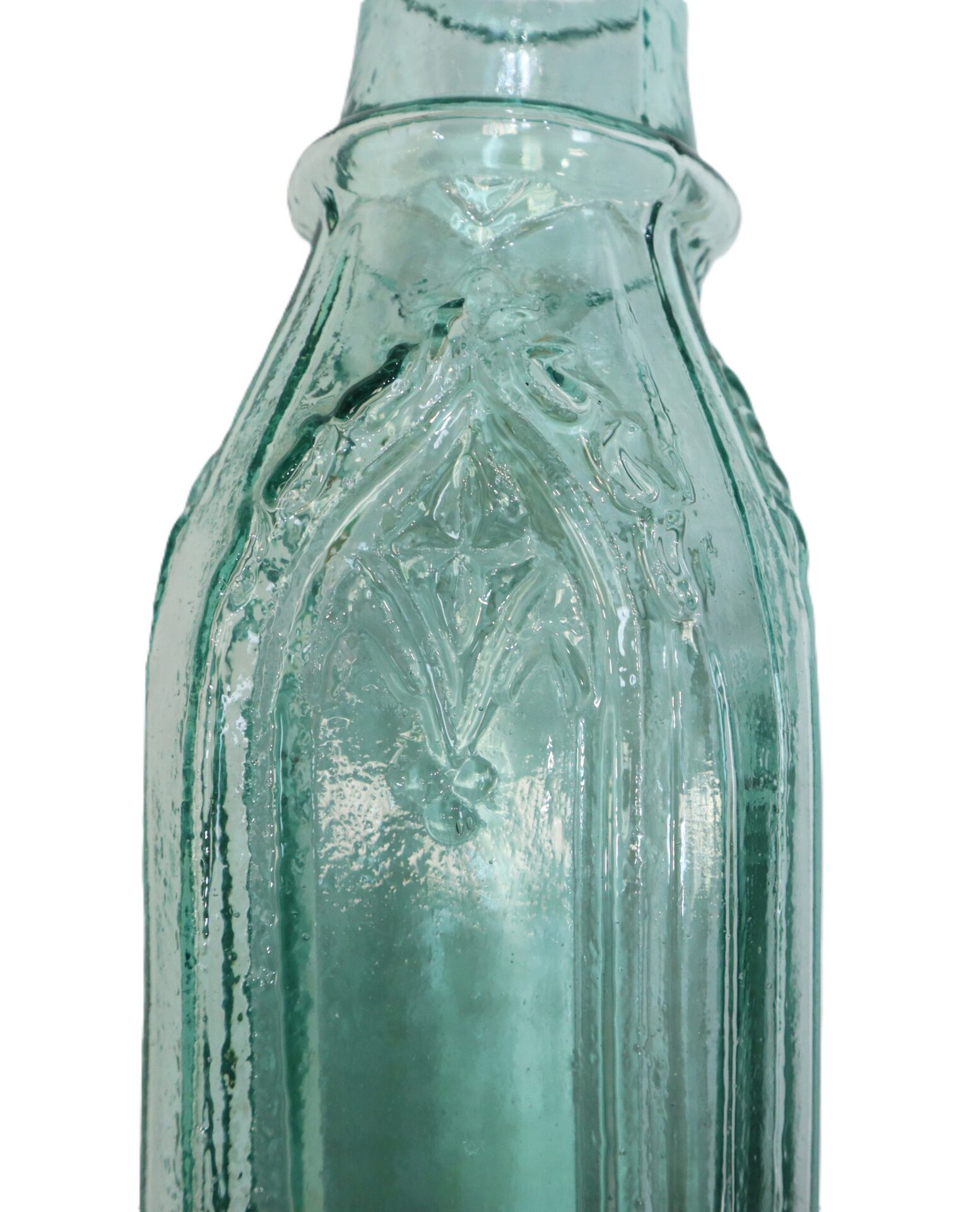Close-up of the upper section of a vintage, textured green glass bottle with raised decorative patterns.