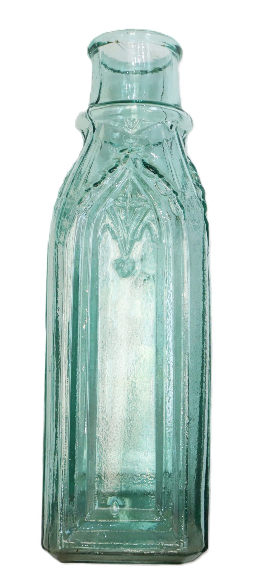 Clear antique glass bottle with embossed rectangular panels and a narrow neck, photographed against a white background.