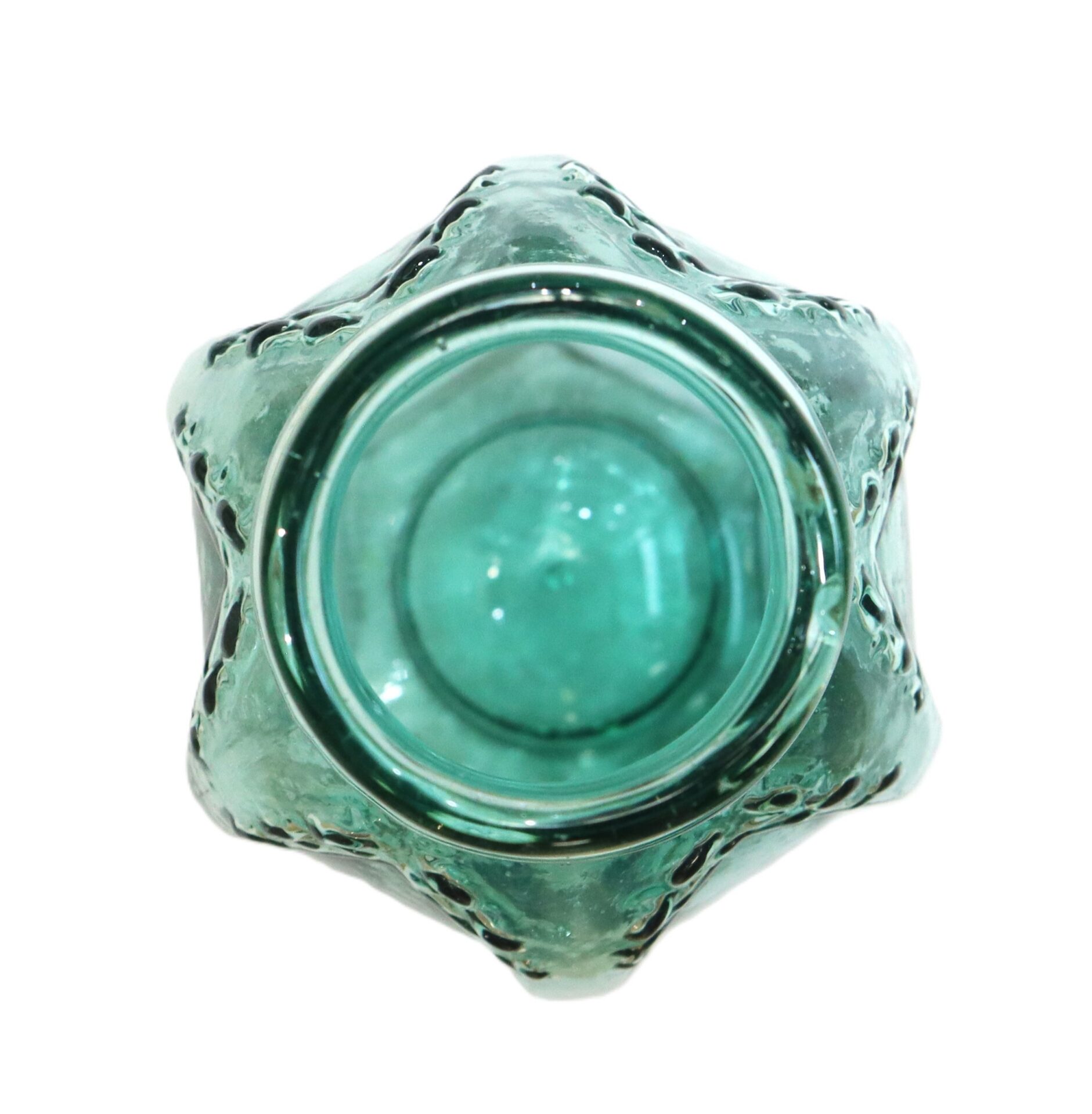 A top-down view of an empty, light green glass bottle with a decorative, textured surface.