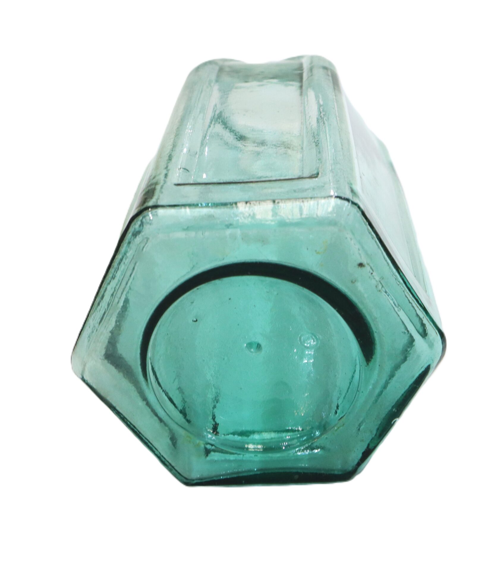 Hexagonal, clear green glass bottle shown from the bottom, with visible seams and a slightly concave base.