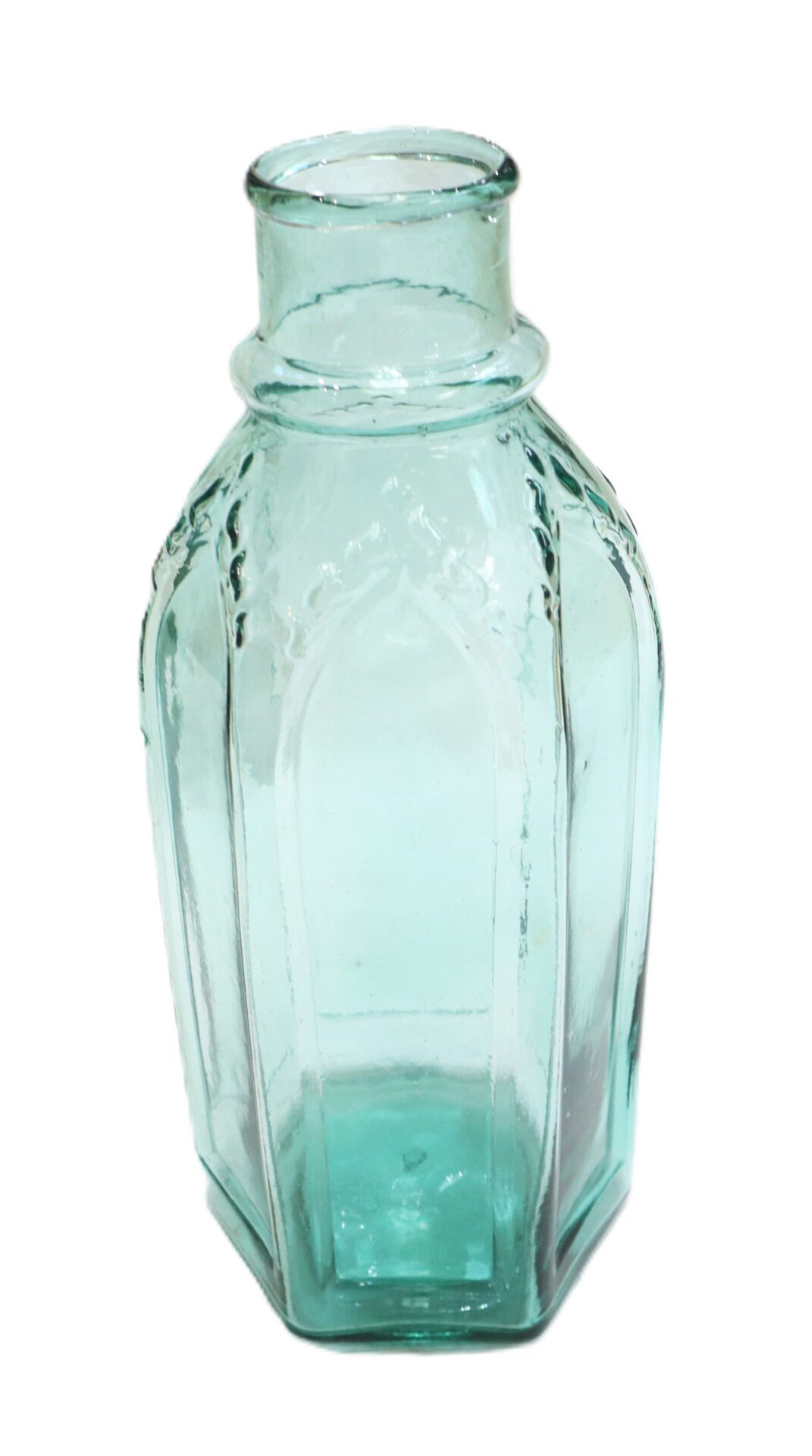 Clear hexagonal glass bottle with a short neck and embossed vertical paneled design.