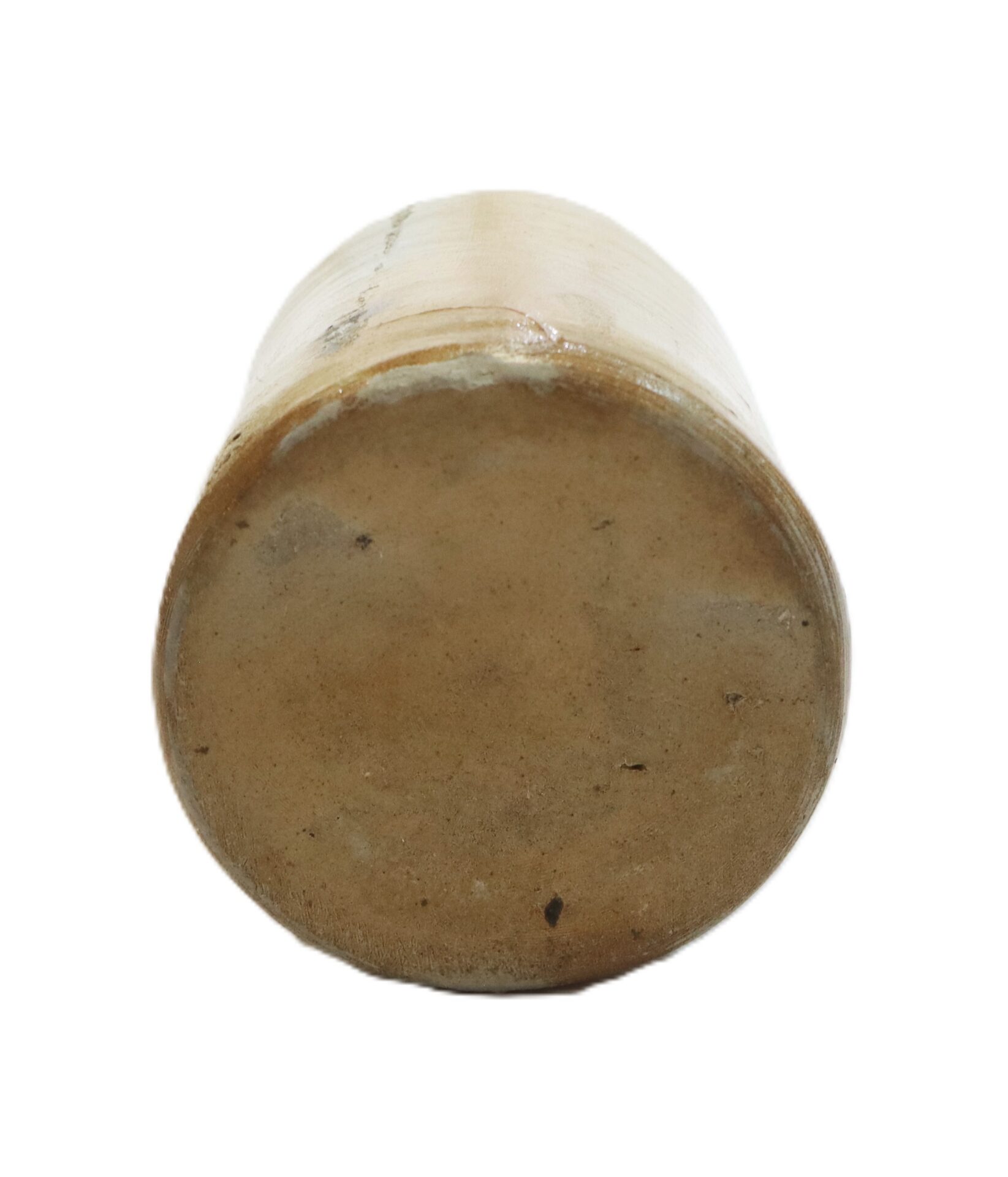 A cylindrical ceramic object shown from the bottom, with a smooth, unglazed base and a beige color.
