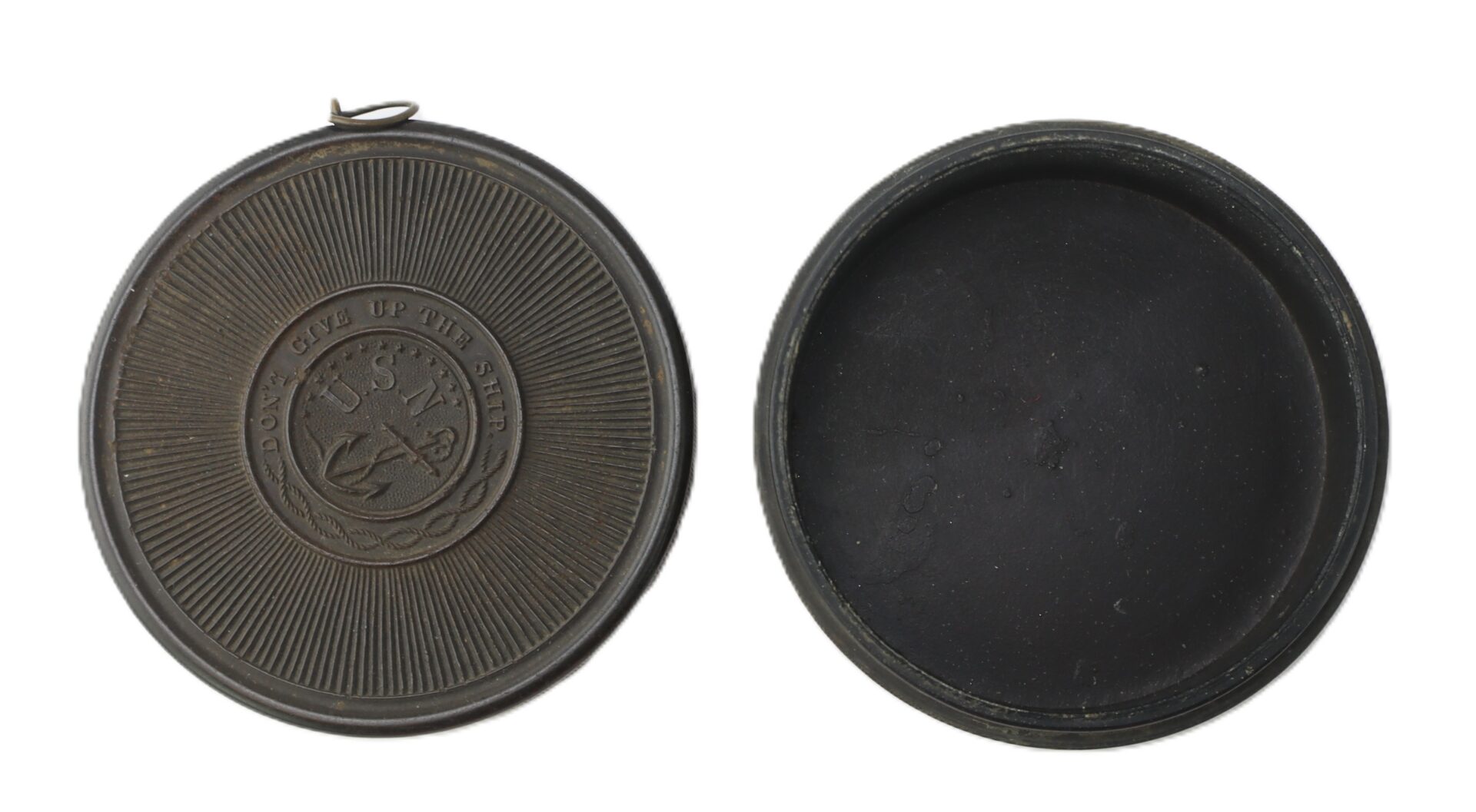 Two views of a round, dark-colored metal container; one side features an emblem with an anchor and the words "Don't Give Up The Ship," the other shows the plain interior.