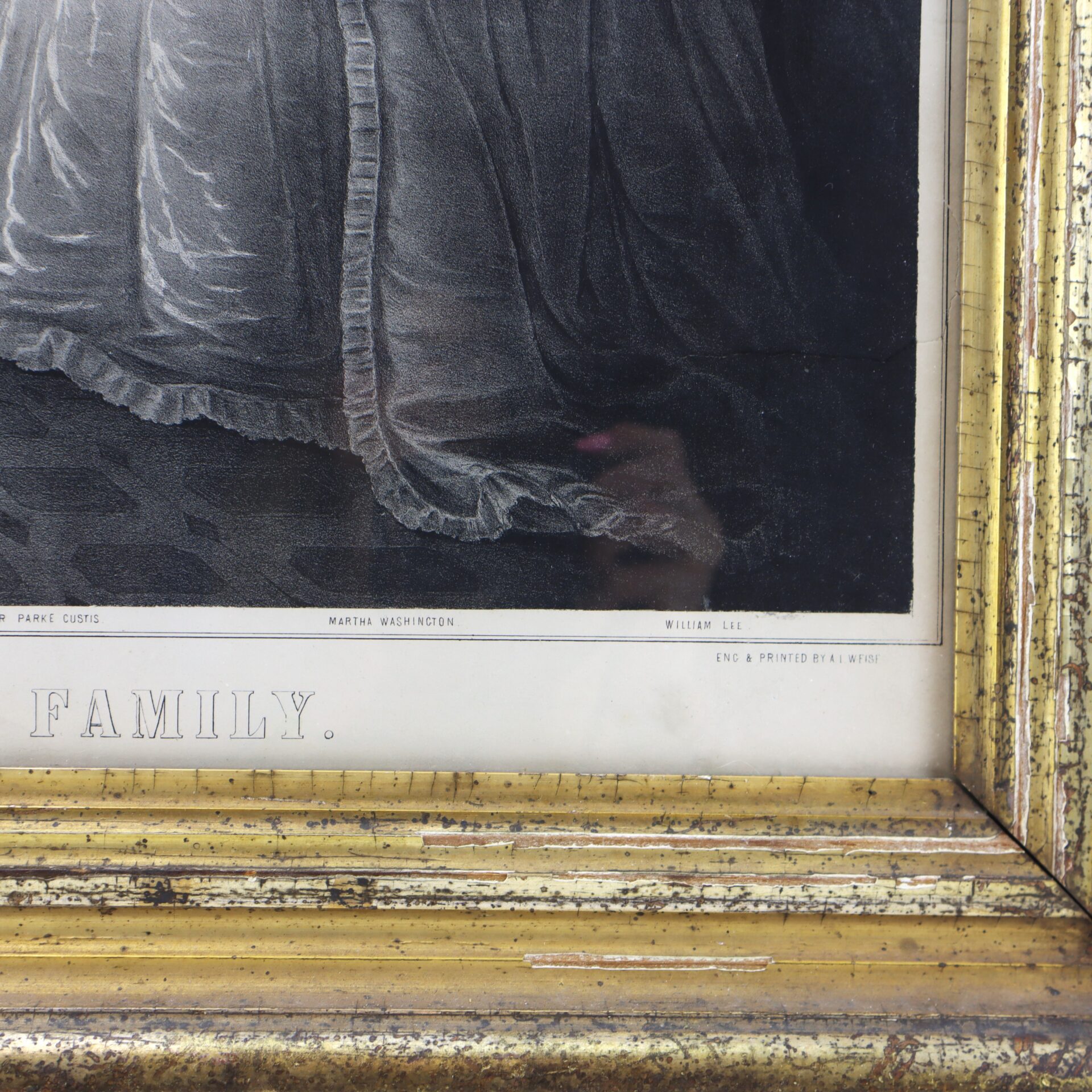 Close-up of the lower part of a framed print showing part of a dress, gold frame, and visible text including "Martha Washington" and "FAMILY.