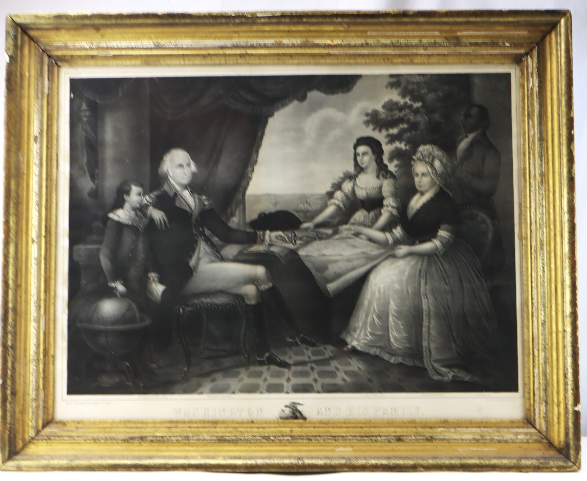 Framed black-and-white painting of George Washington seated with his family, including three other figures, in a formal indoor setting with a landscape visible in the background.
