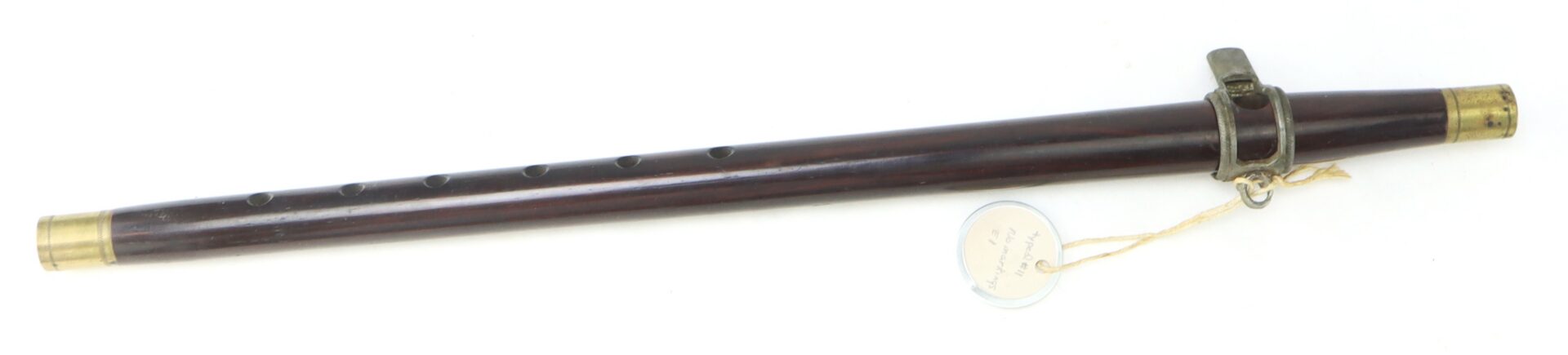 The Civil War–Era Fife with Brass Fittings, Gettysburg Provenance, features six finger holes and a metal key mechanism and is displayed with a tag attached by string.