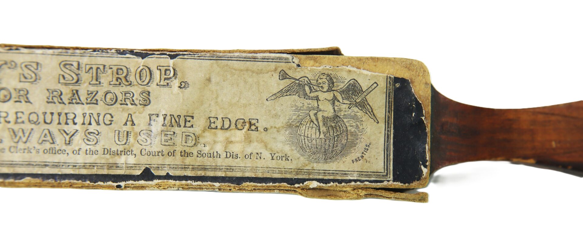 A close-up of a J.R. Torrey’s Patent Razor Strop, dated 1861, shows its worn paper label with an illustration of an angel blowing a horn and decorative text.