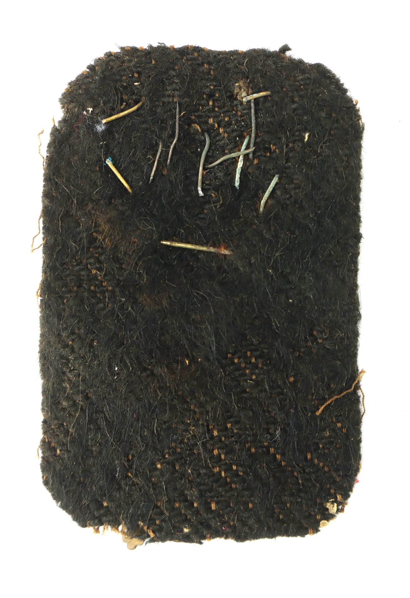 A rectangular piece of worn, dark-colored woven fabric with loose threads and small twigs embedded on its surface, set against a white background.
