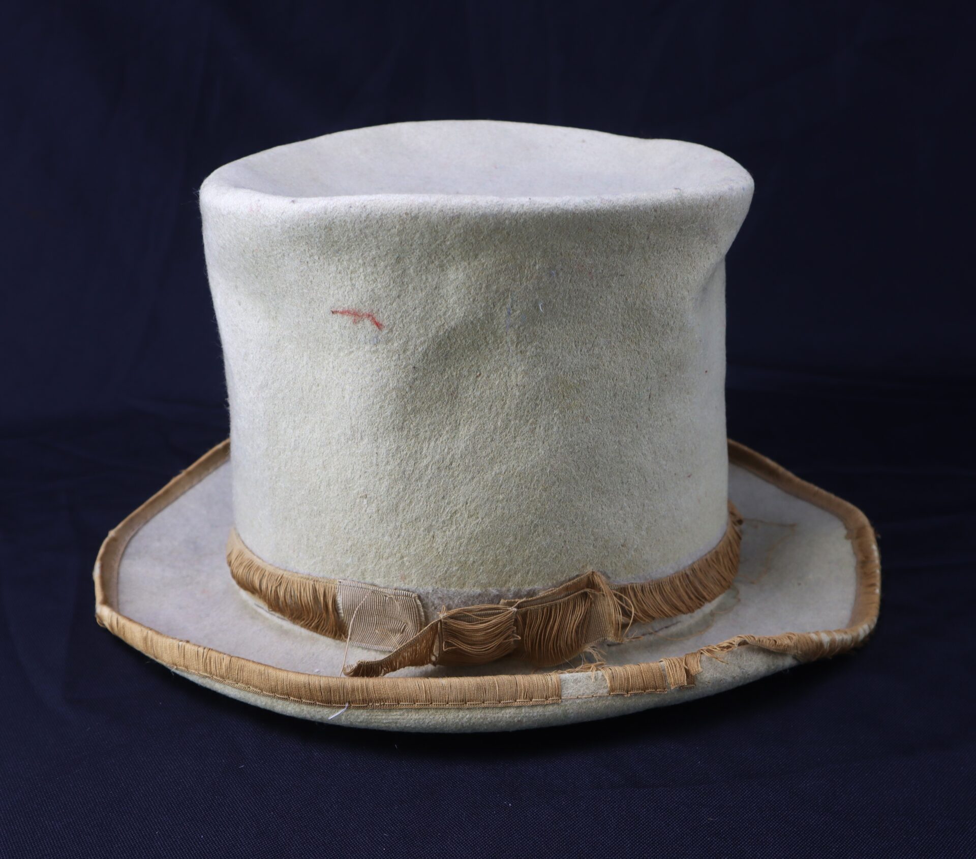 The Awesome Top Hat for the 1888 Republican Campaign features a light color, frayed ribbon band, and visible signs of age, shown against a dark background.