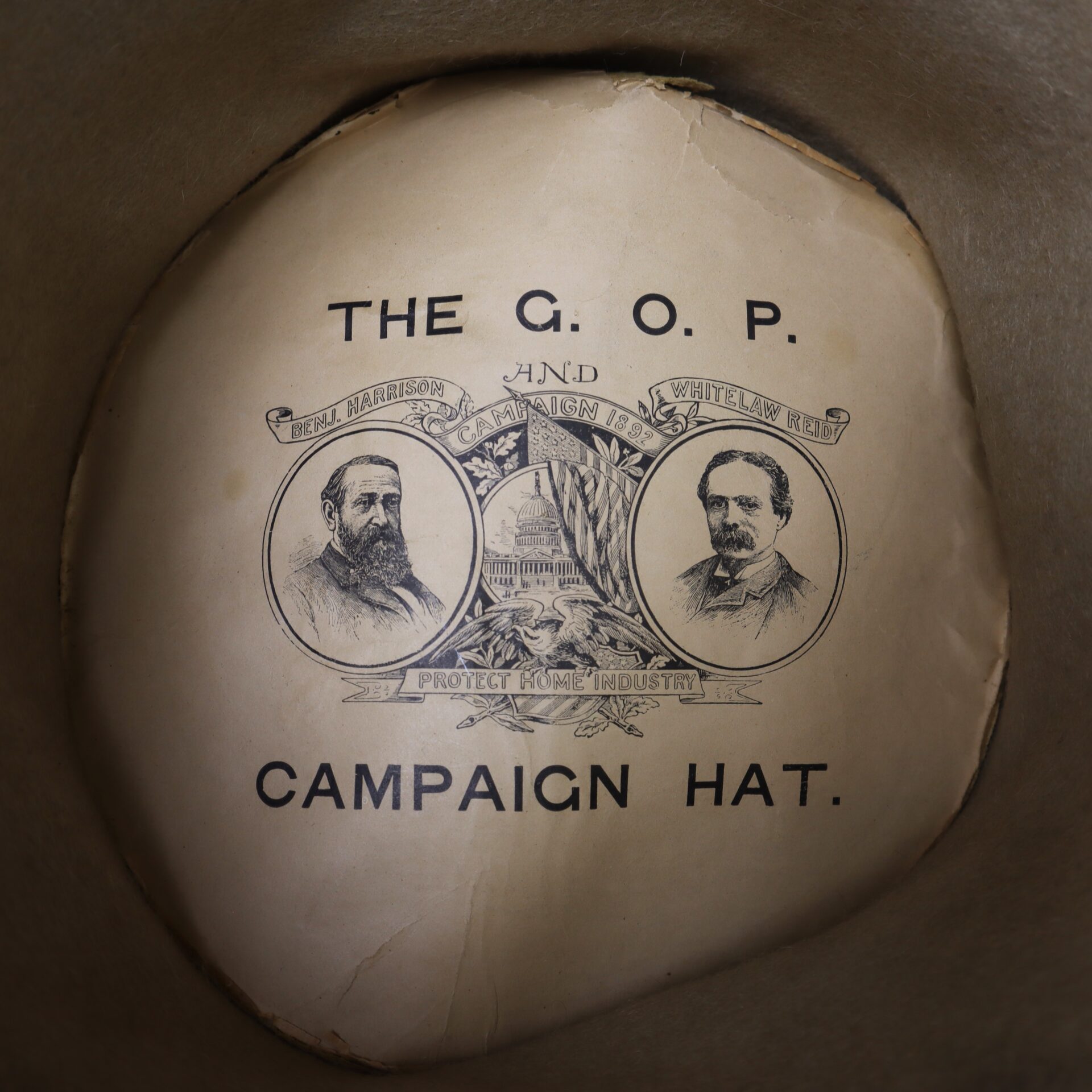 Inside an Awesome Top Hat for the 1888 Republican Campaign, portraits of Benjamin Harrison and Whitelaw Reid appear with the text: "THE G.O.P. CAMPAIGN HAT. Protect Home Industry.