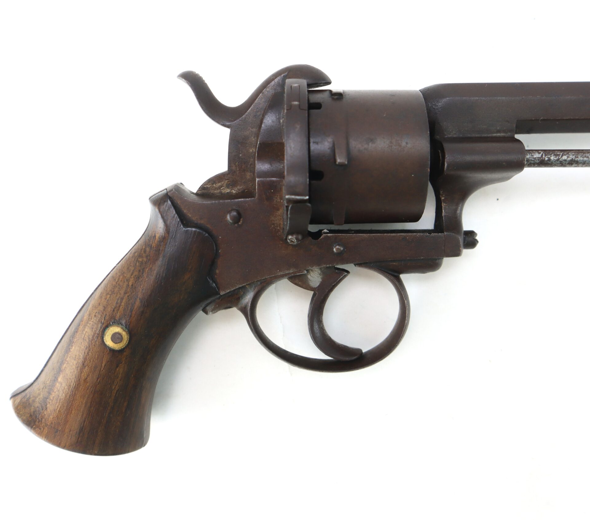 Close-up of the handle and trigger area of an antique revolver with a wooden grip and a dark metal frame.